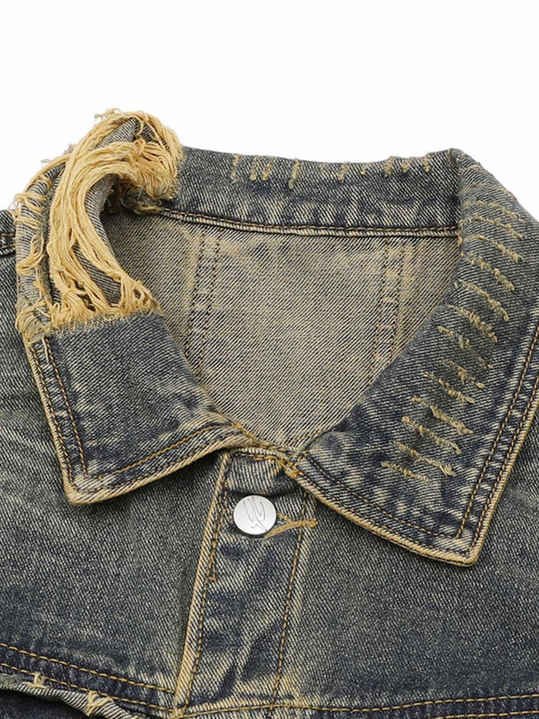 A detailed view of the raw edge and distressed collar on a TALISHKO denim jacket.