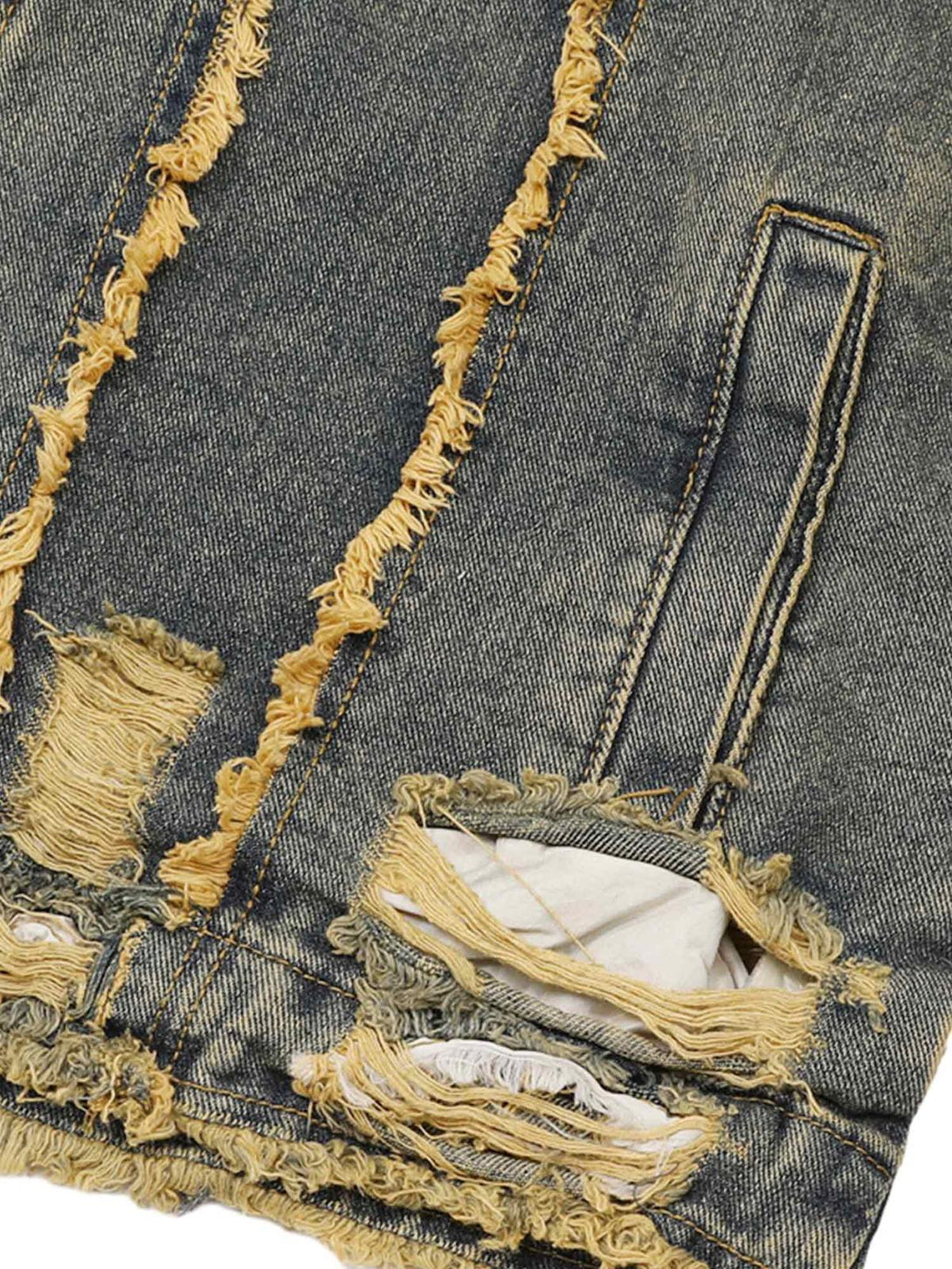 A close-up of TALISHKO's distressed denim jacket, highlighting raw edge details and texture.