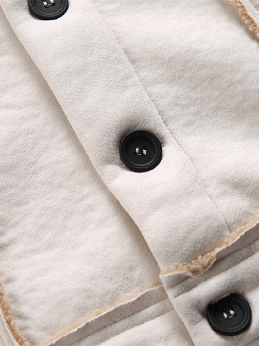 Zoomed-in texture of TALISHKO fleece jacket showcasing black buttons and raw edge detailing.