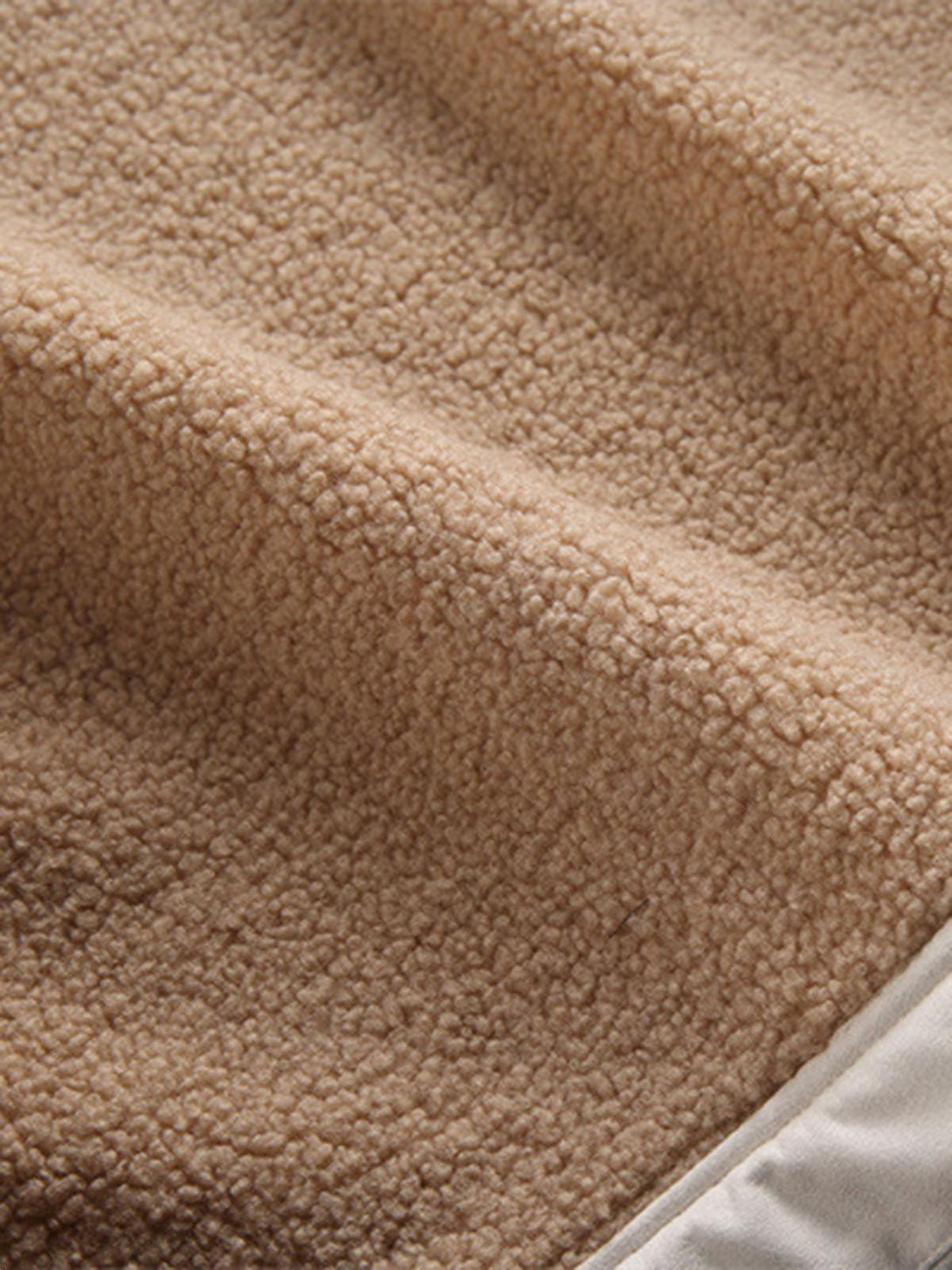 A close-up of TALISHKO fleece jacket fabric, highlighting its cozy texture and raw edge design.