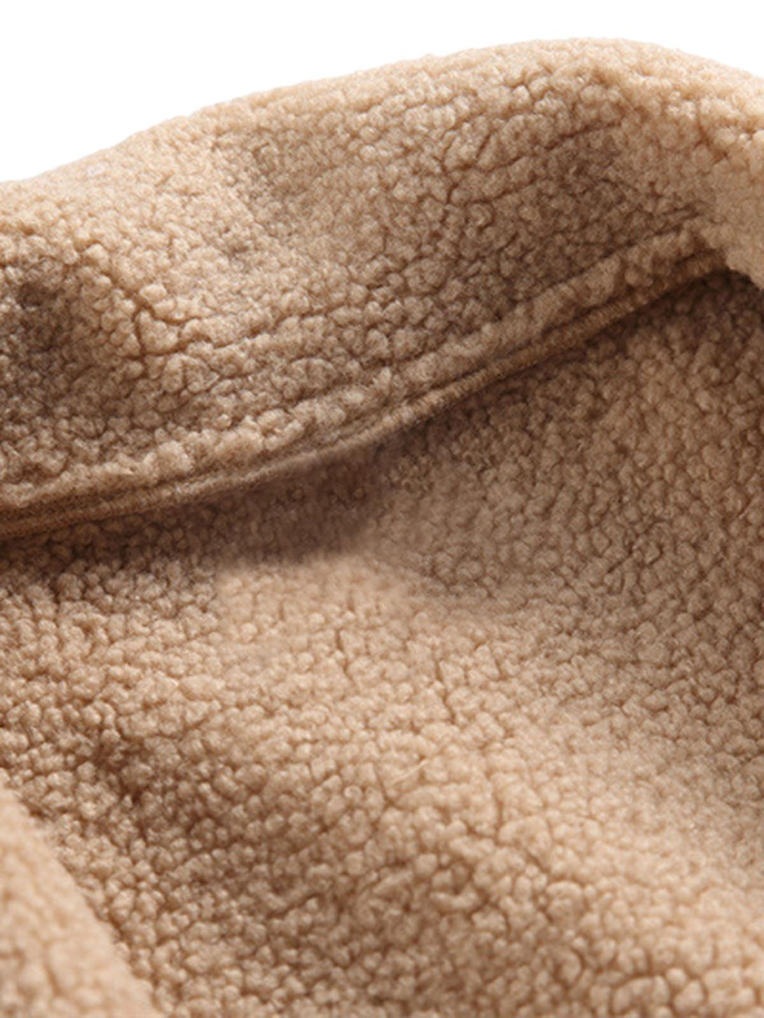 A tight crop highlighting the cozy texture and raw edge finish of a TALISHKO fleece jacket.