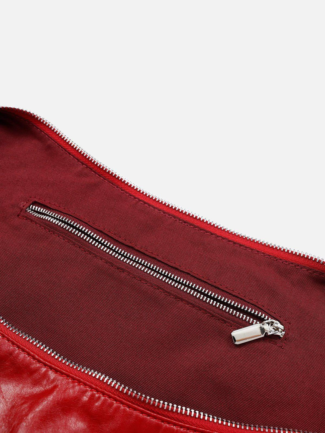 Intricate view of TALISHKO red faux leather bag's interior zipper and textured lining.
