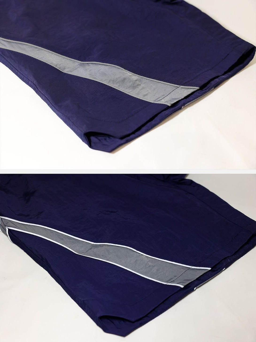Navy training shorts with reflective stripes by TALISHKO, highlighting side detail.