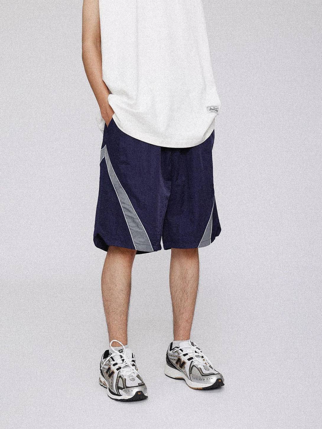 TALISHKO reflective stripe training shorts styled with a casual top and sneakers for a relaxed look.