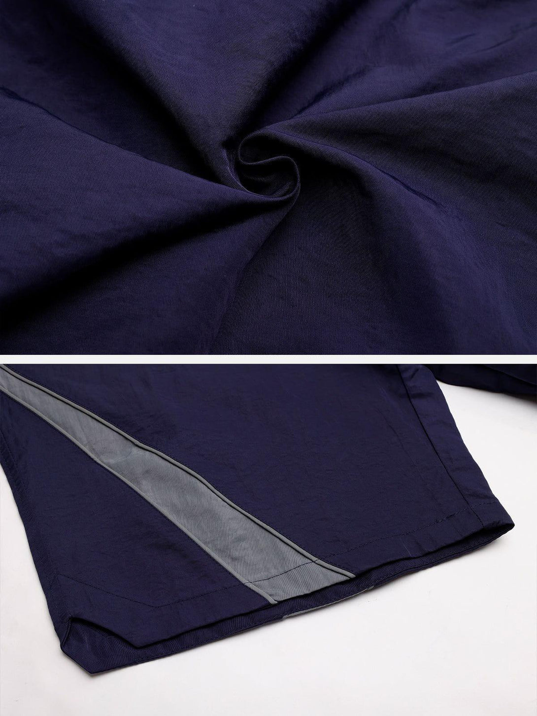 Intricate look at TALISHKO navy training shorts, showcasing reflective stripe detail and fabric texture.