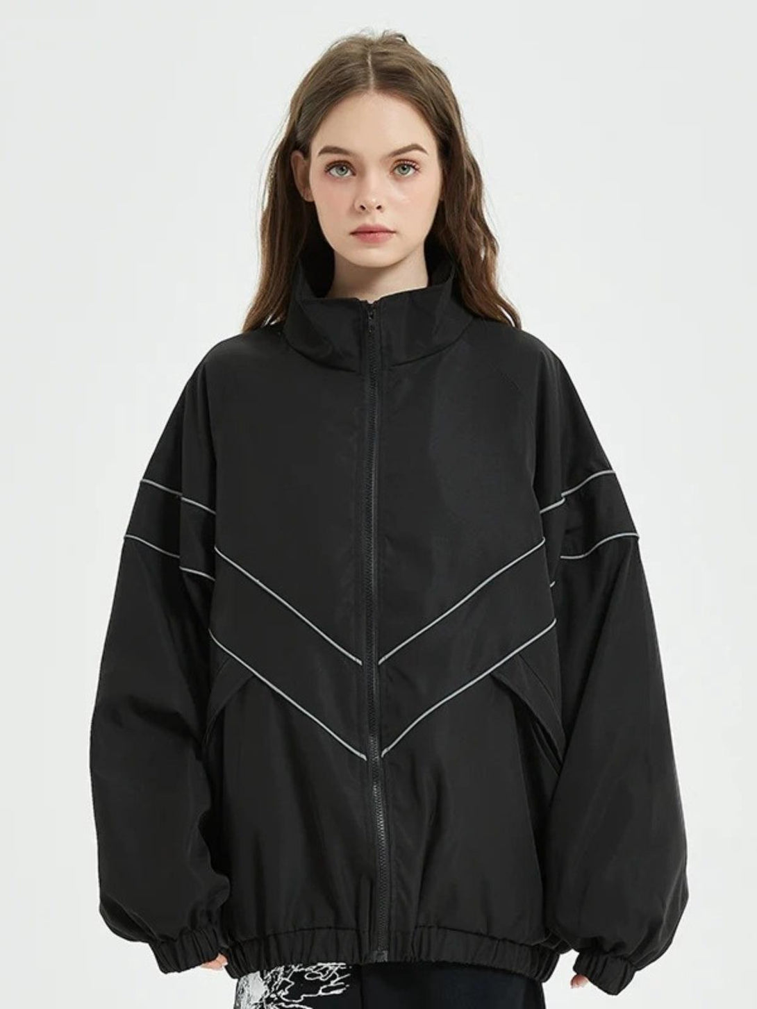 Model wearing a black reflective striped jacket by TALISHKO, showcasing a relaxed fit.