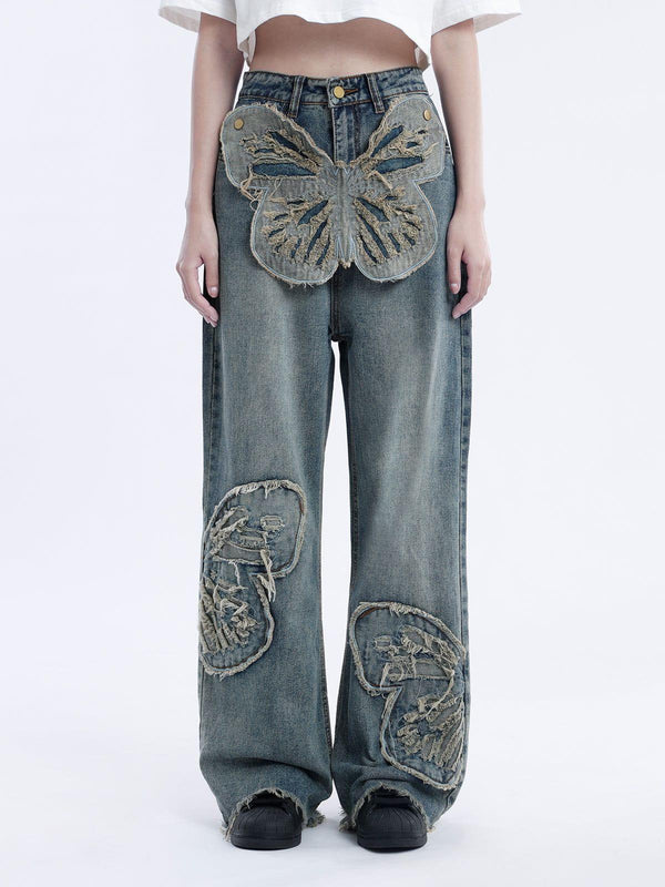 Model wearing TALISHKO loose jeans with a large butterfly design and distressed detailing.