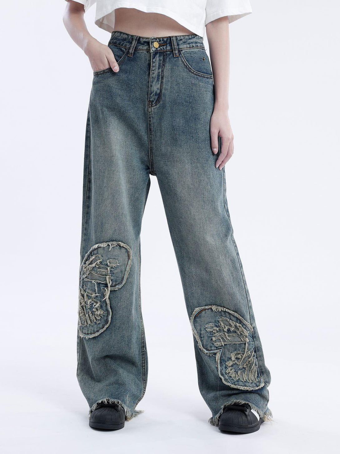 Loose jeans by TALISHKO featuring a unique butterfly patch and distressed hem design.