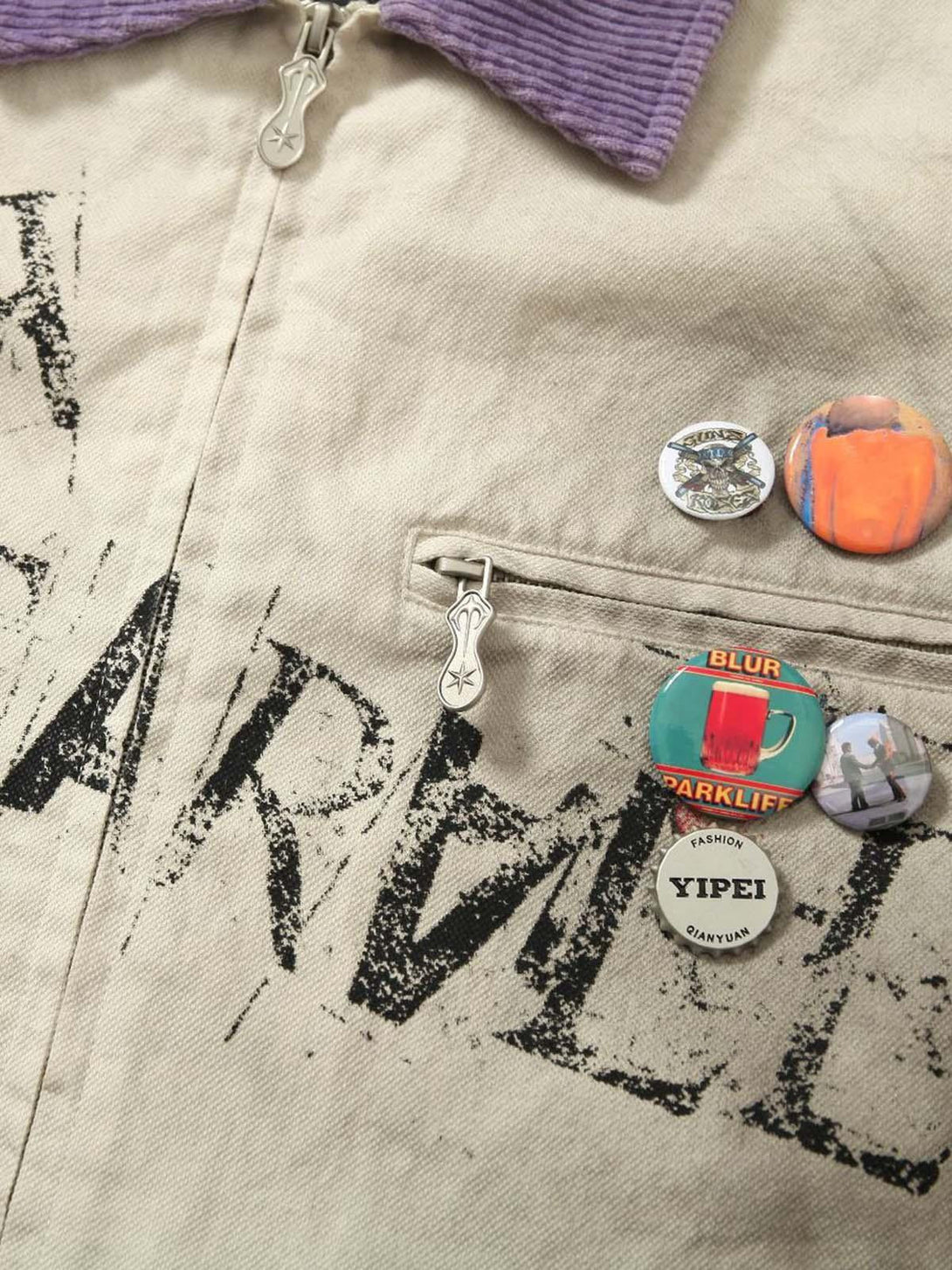 A close-up of TALISHKO's jacket featuring retro badges and unique graphic details.