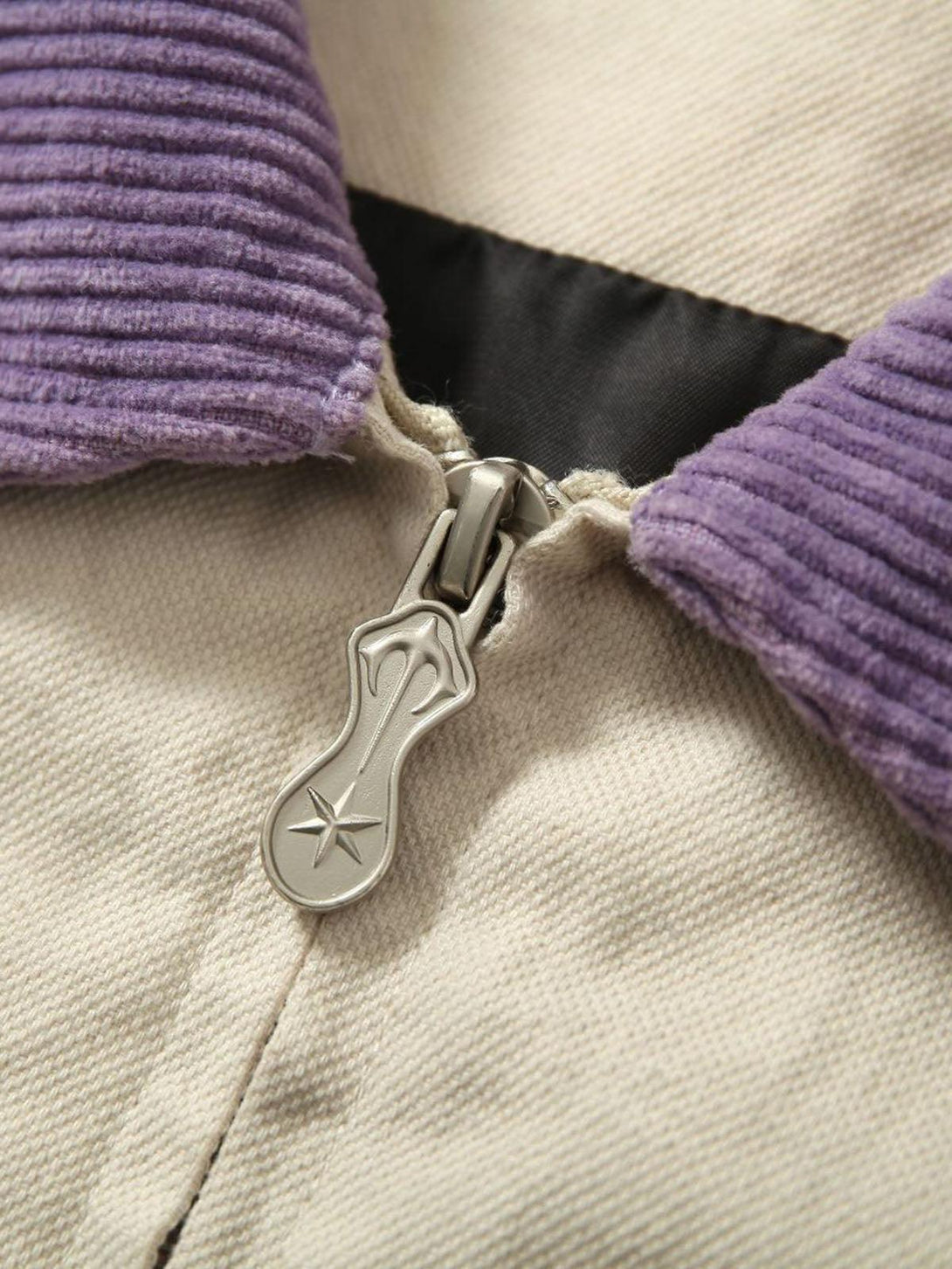 Detailed view of TALISHKO jacket's zipper and purple corduroy collar, showcasing unique style.