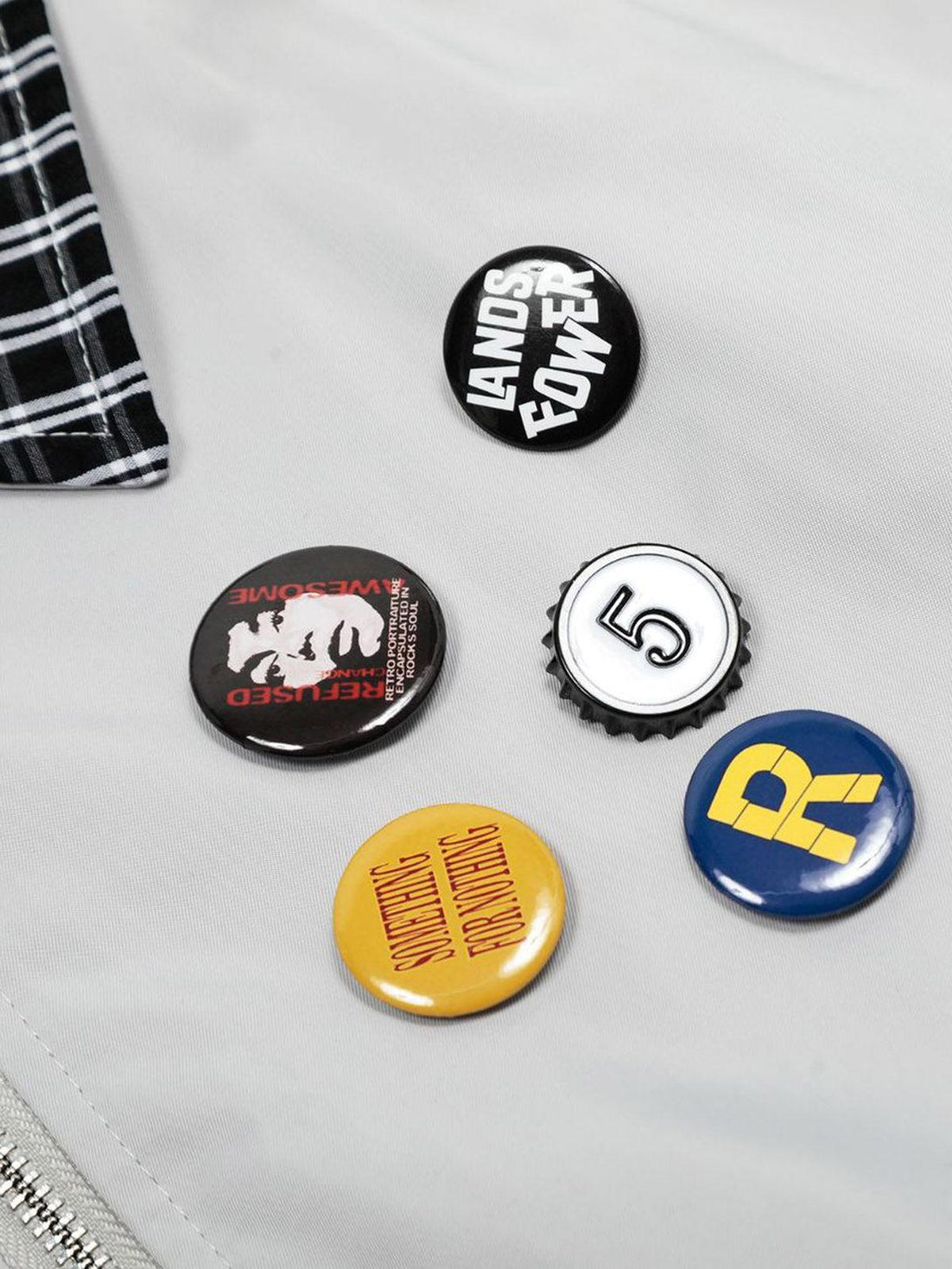 A close-up of badges on a TALISHKO retro jacket, highlighting vintage-inspired designs.