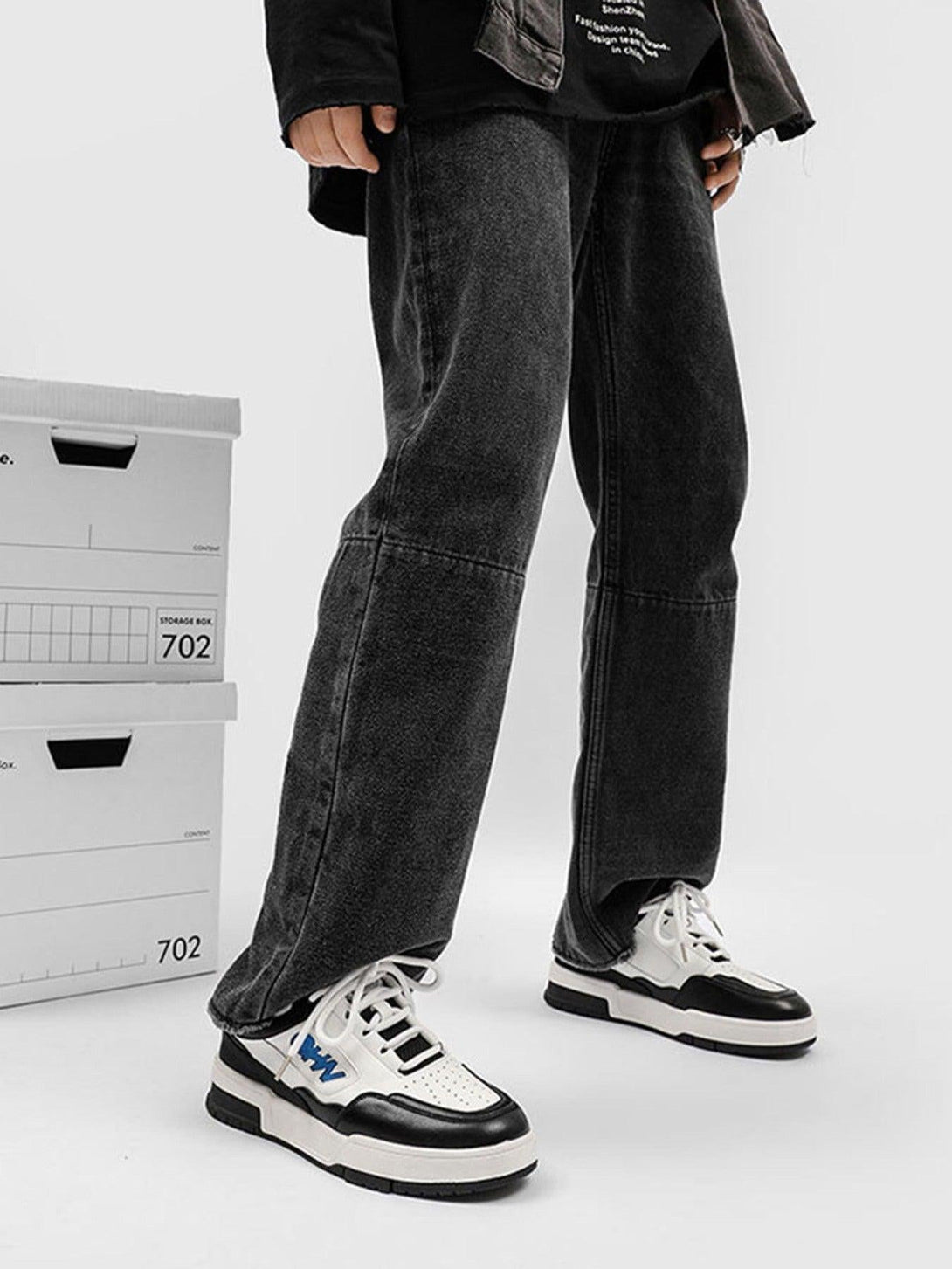 TALISHKO retro sneakers in black and white styled with dark jeans for a trendy street look.