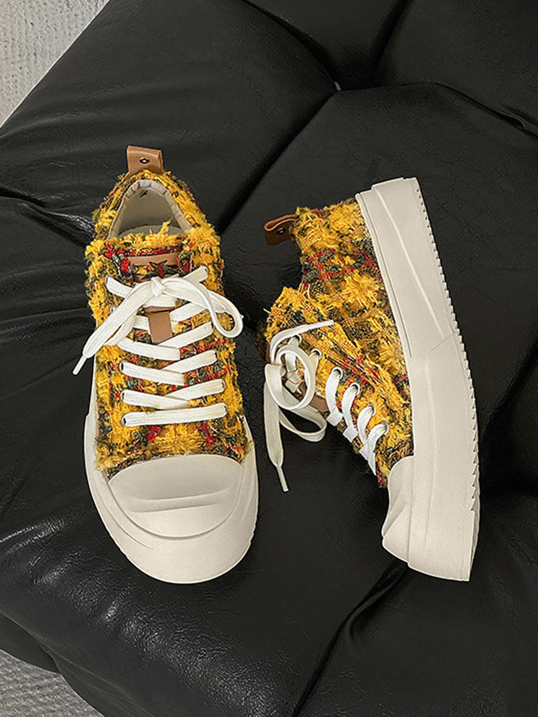Retro canvas sneakers by TALISHKO in yellow, featuring a unique textured design on a black couch.