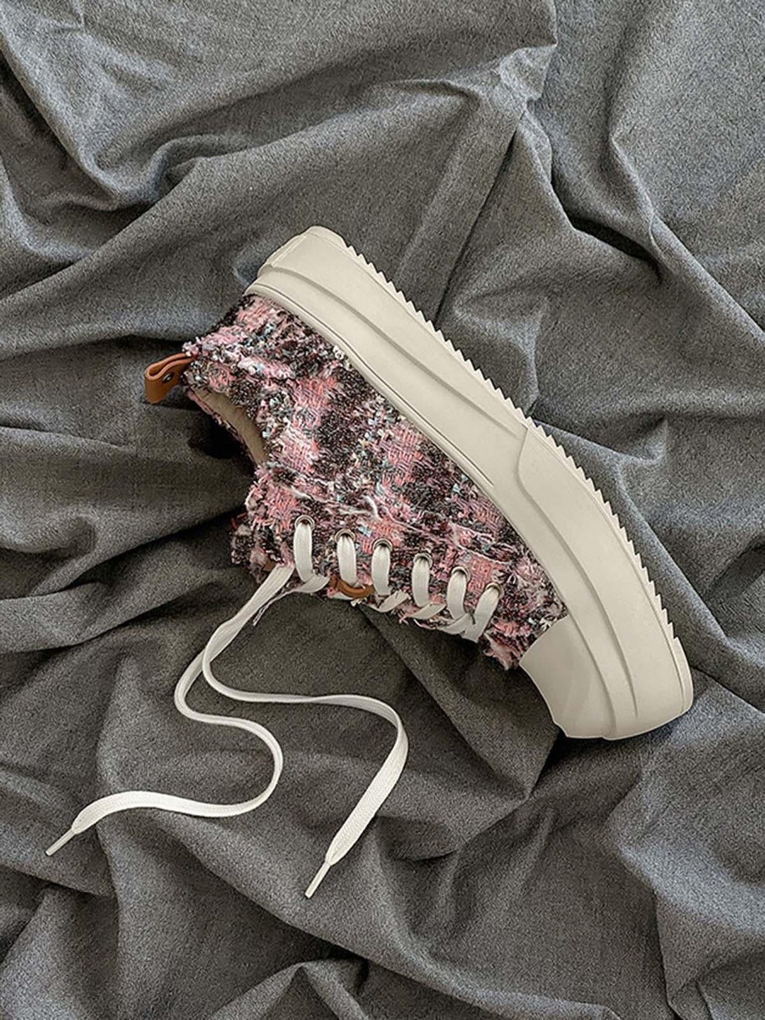 TALISHKO sneakers featuring a pink and black textured side view on a gray fabric backdrop.