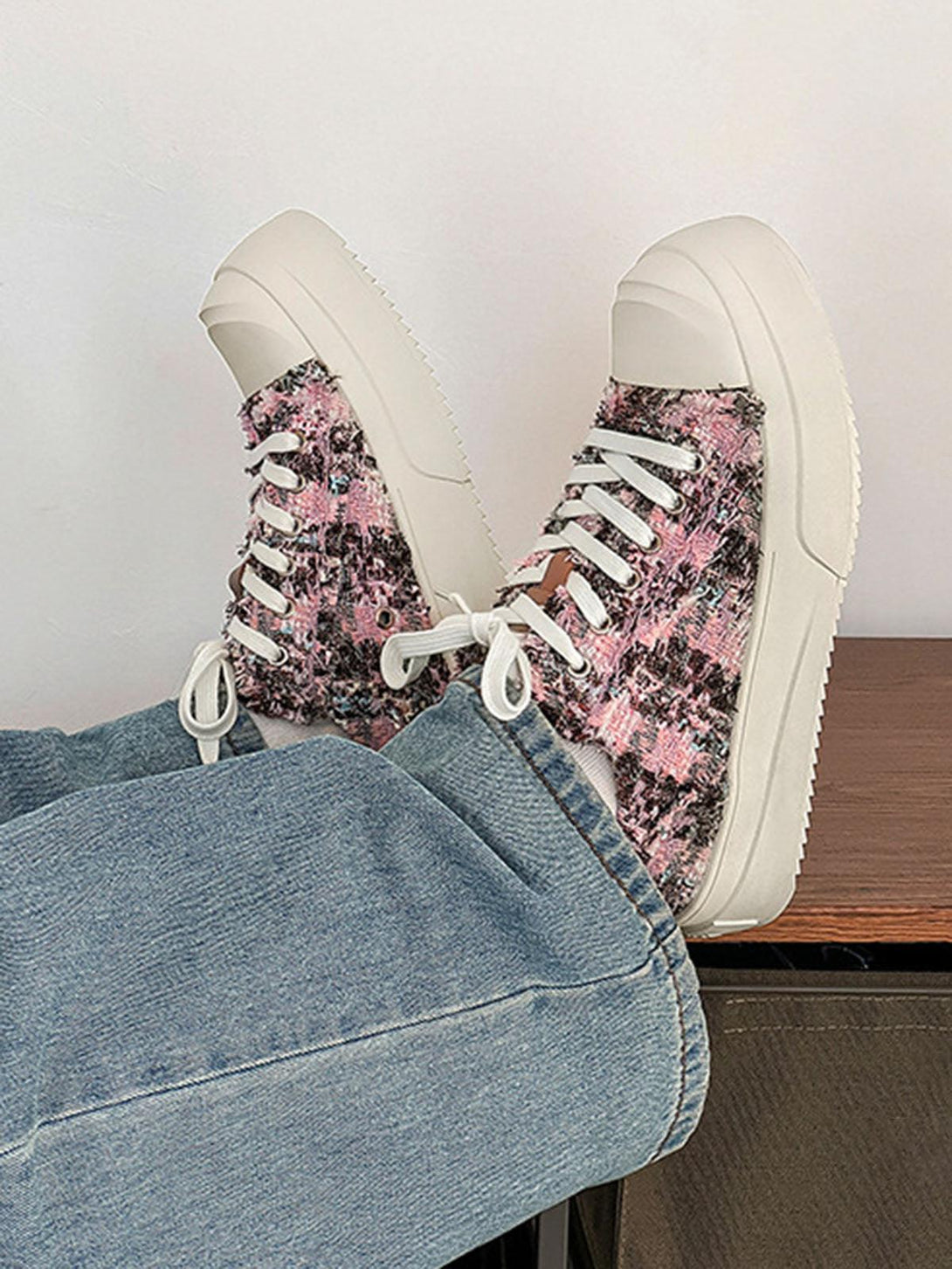 TALISHKO sneakers with a pink and black textured design, styled with casual denim jeans.