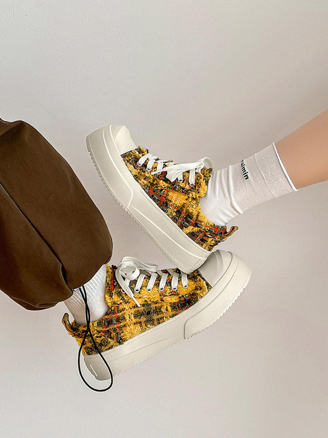 Retro canvas sneakers by TALISHKO, featuring a vibrant multicolored texture and white soles.