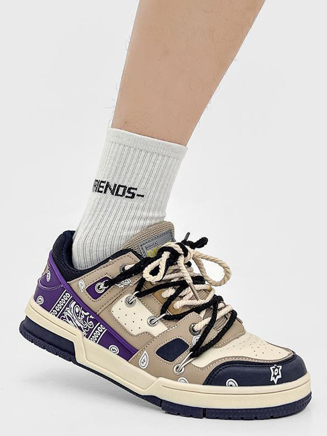 TALISHKO retro sneakers with beige and purple paisley design, styled with white socks.