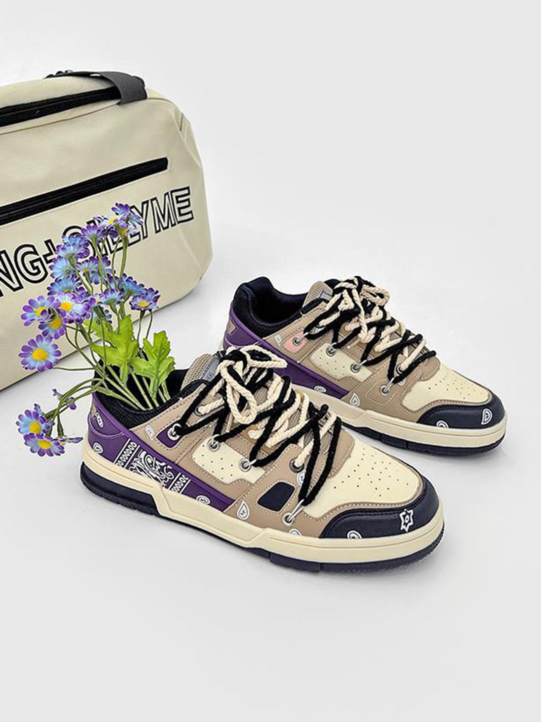 Retro-style sneakers by TALISHKO, featuring beige and purple paisley design, next to a stylish bag.