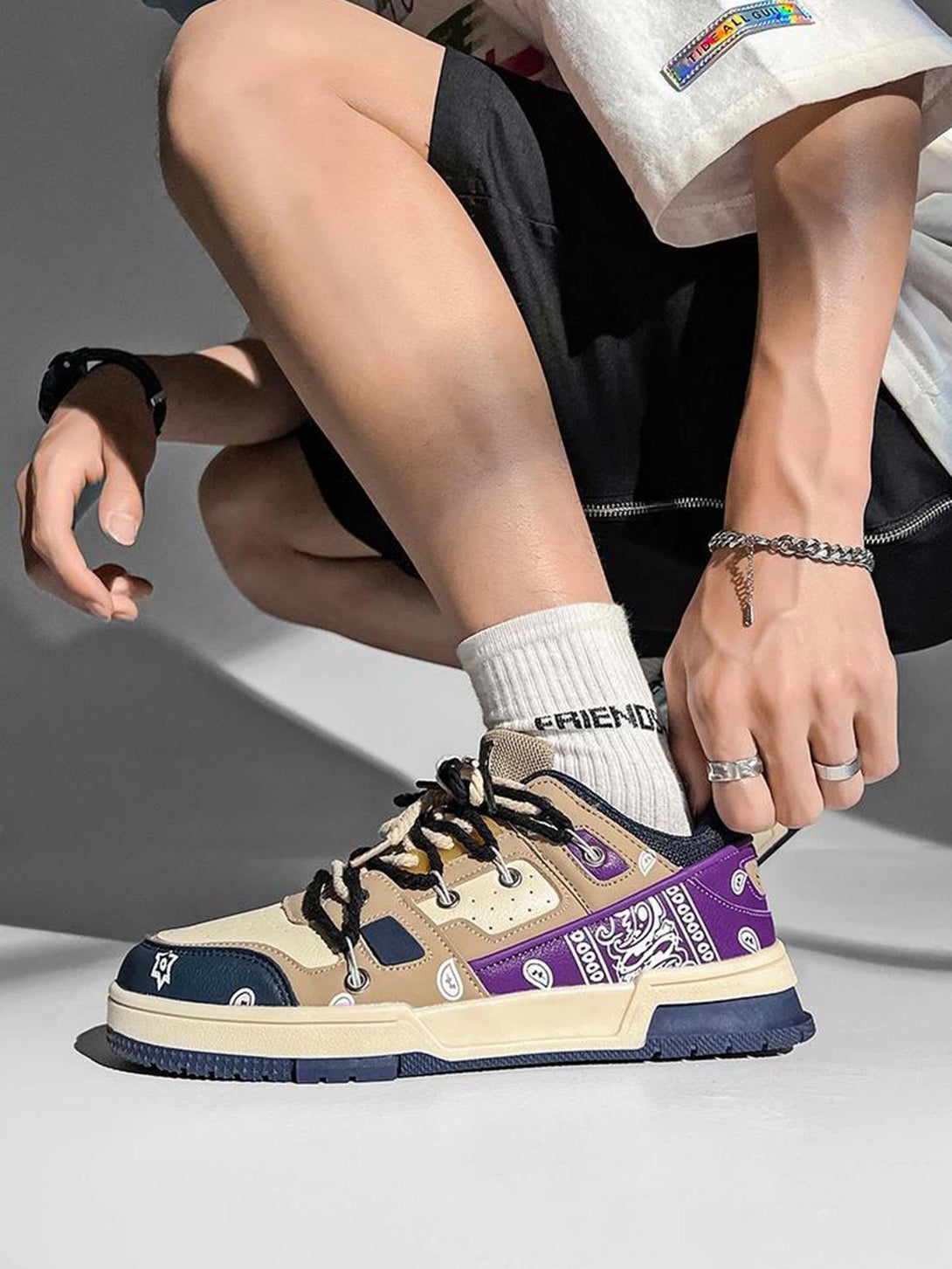 TALISHKO sneakers in beige and purple with paisley accents, paired with "FRIENDS" socks.