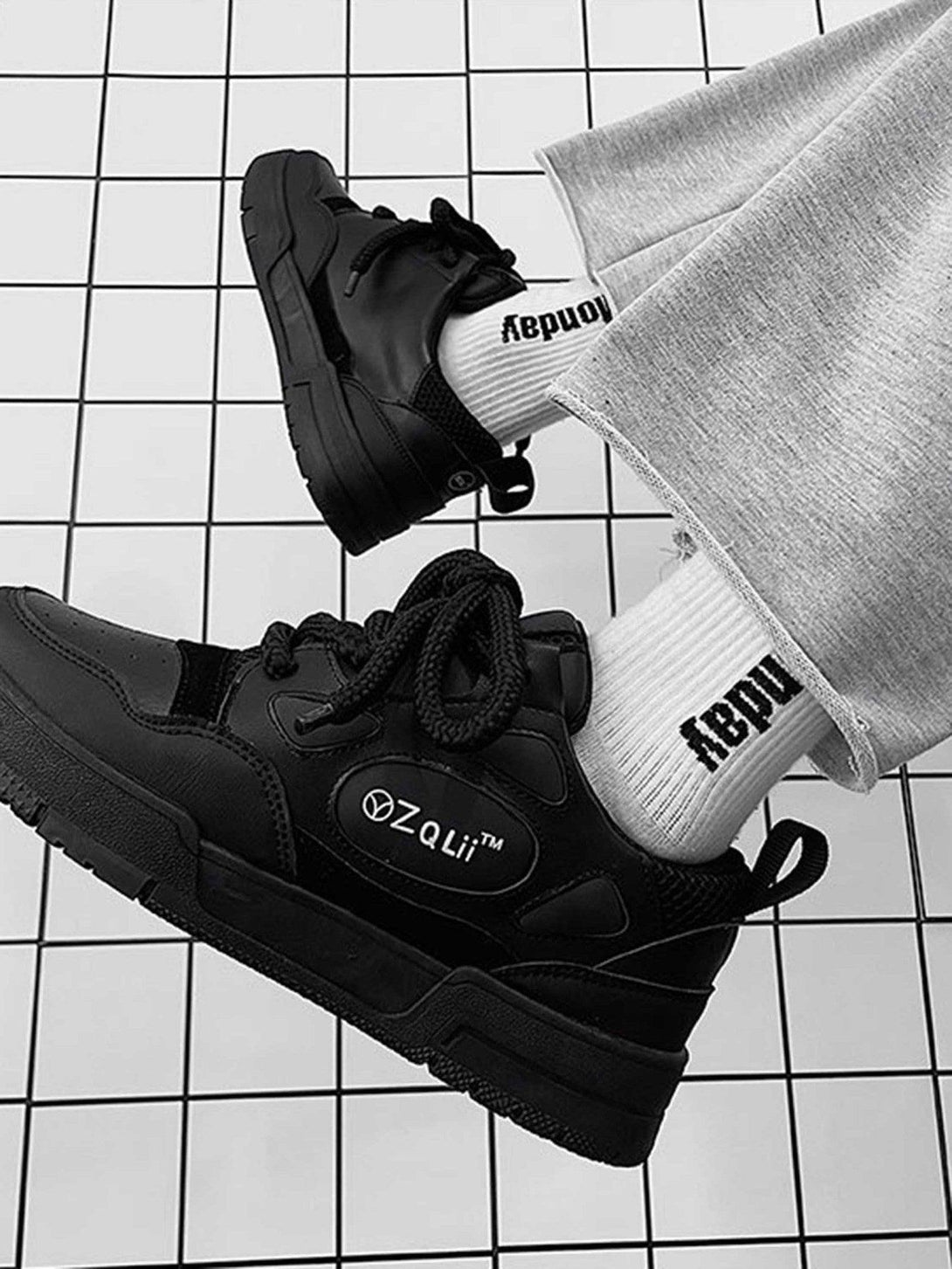 Black TALISHKO retro casual board shoes paired with gray pants and white branded socks.