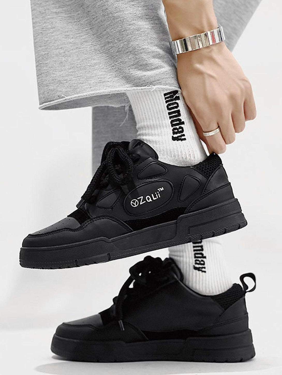 TALISHKO retro casual board shoes in black, worn with white socks and relaxed gray pants.