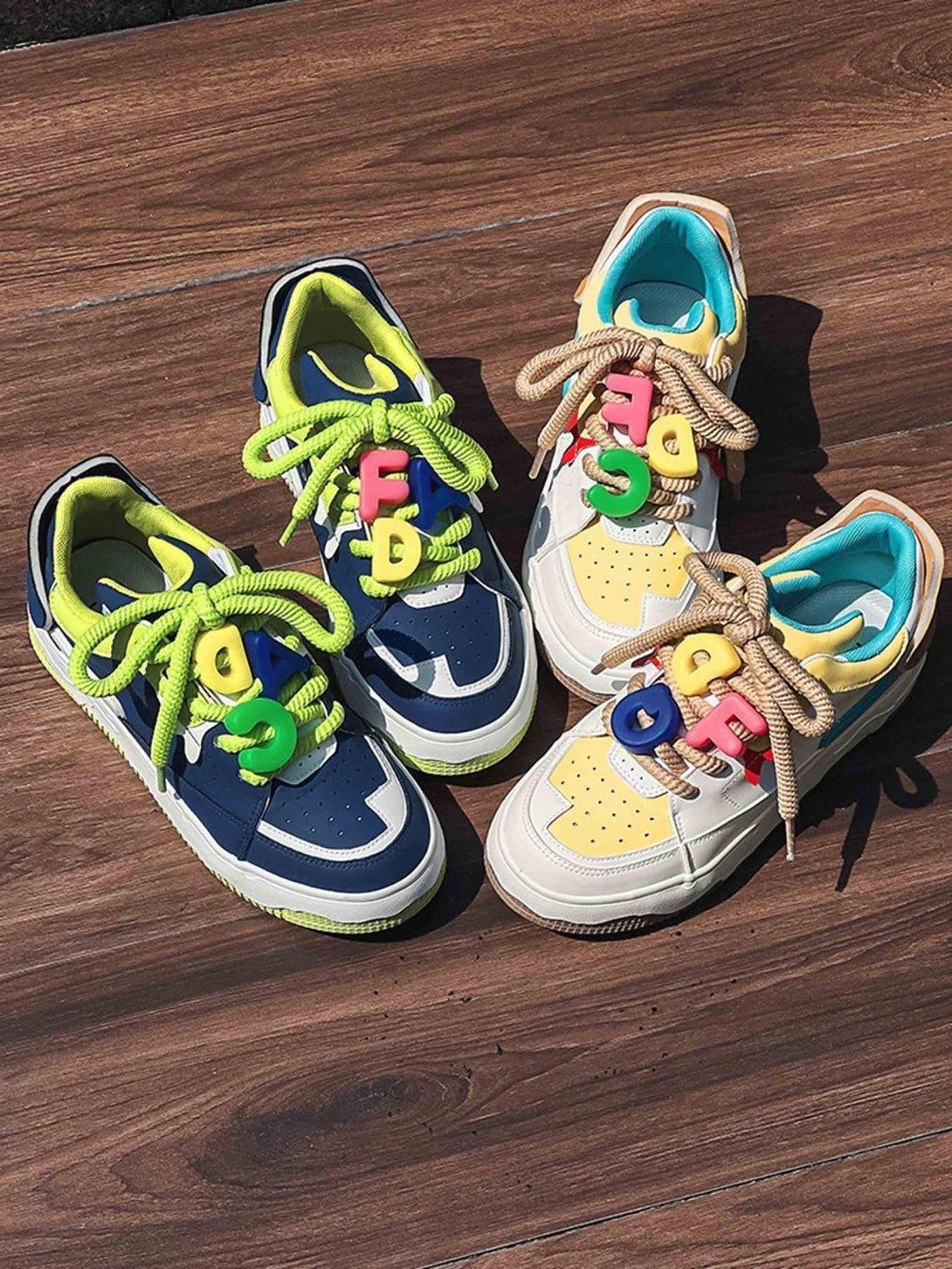 Colorful TALISHKO sneakers with letter charms on wooden floor, showcasing playful style.