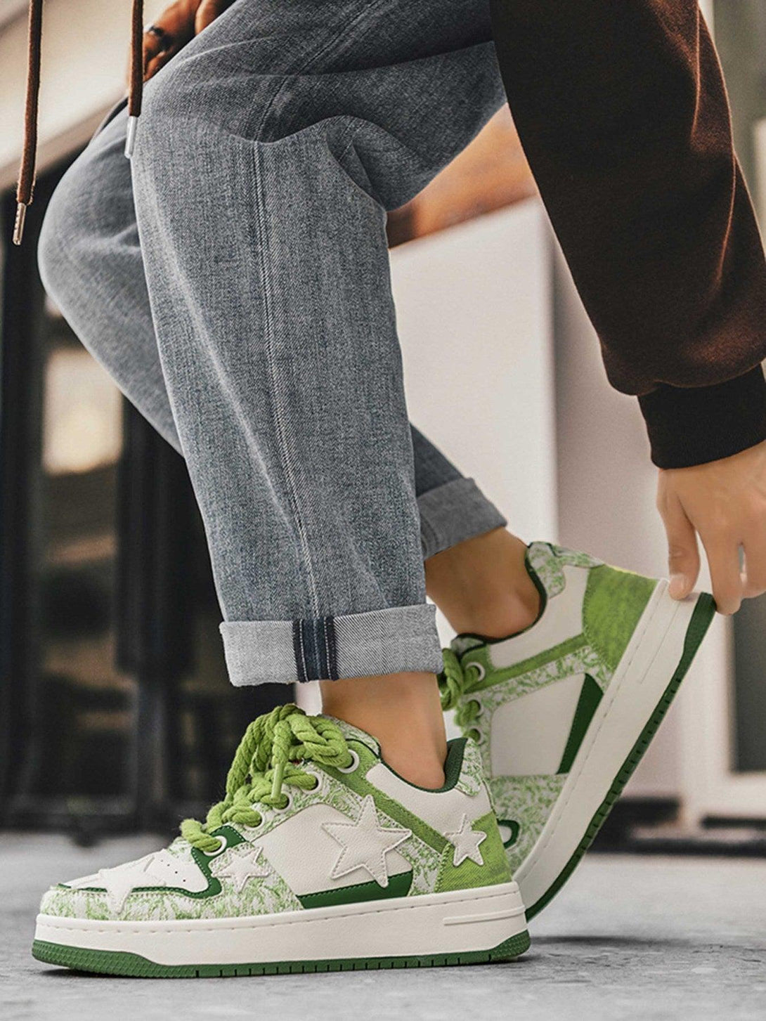 TALISHKO retro casual sneakers with green star accents, worn with rolled jeans for a stylish look.