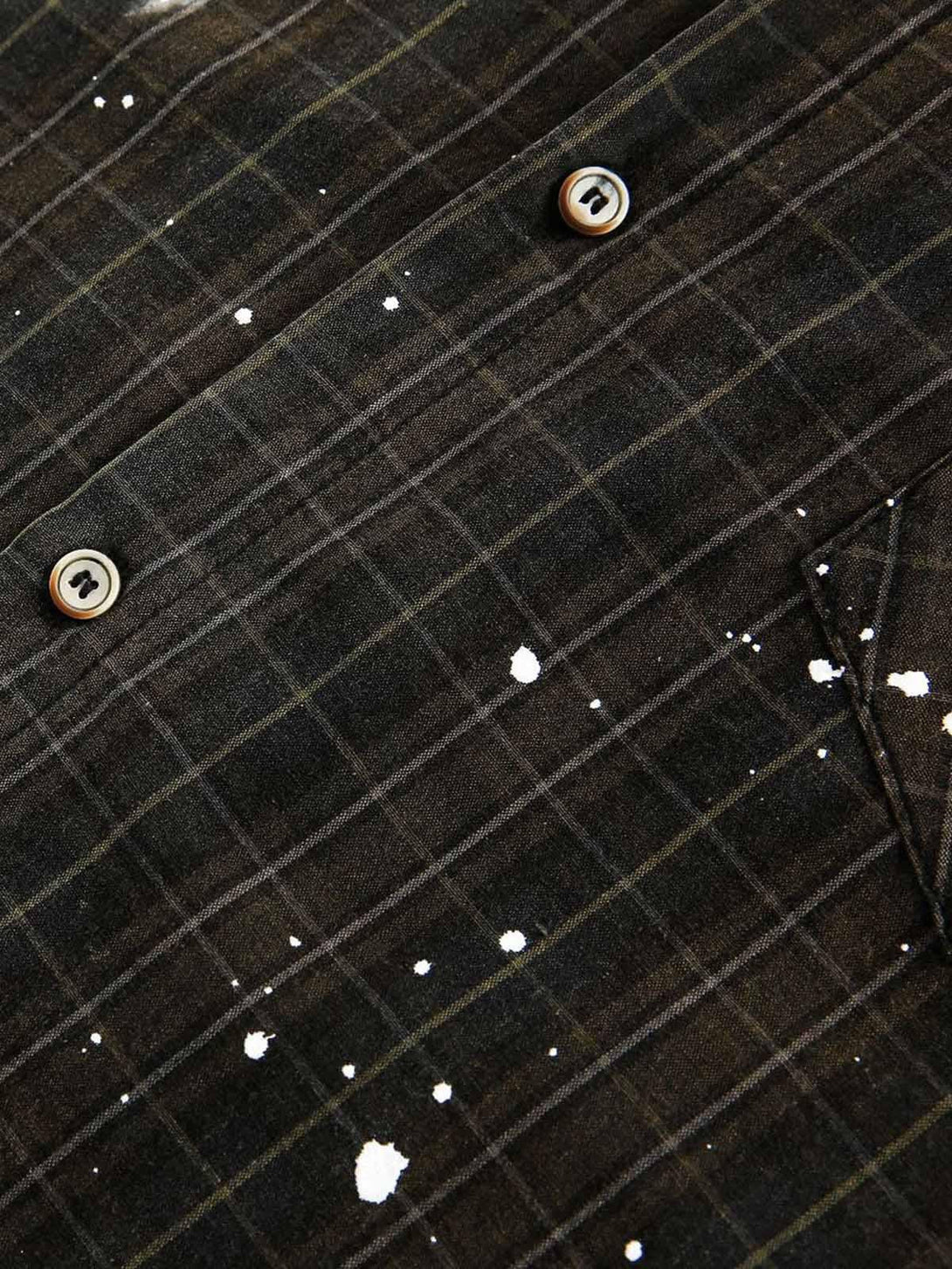 A detailed view of the TALISHKO retro plaid shirt, highlighting its unique paint splatter design.