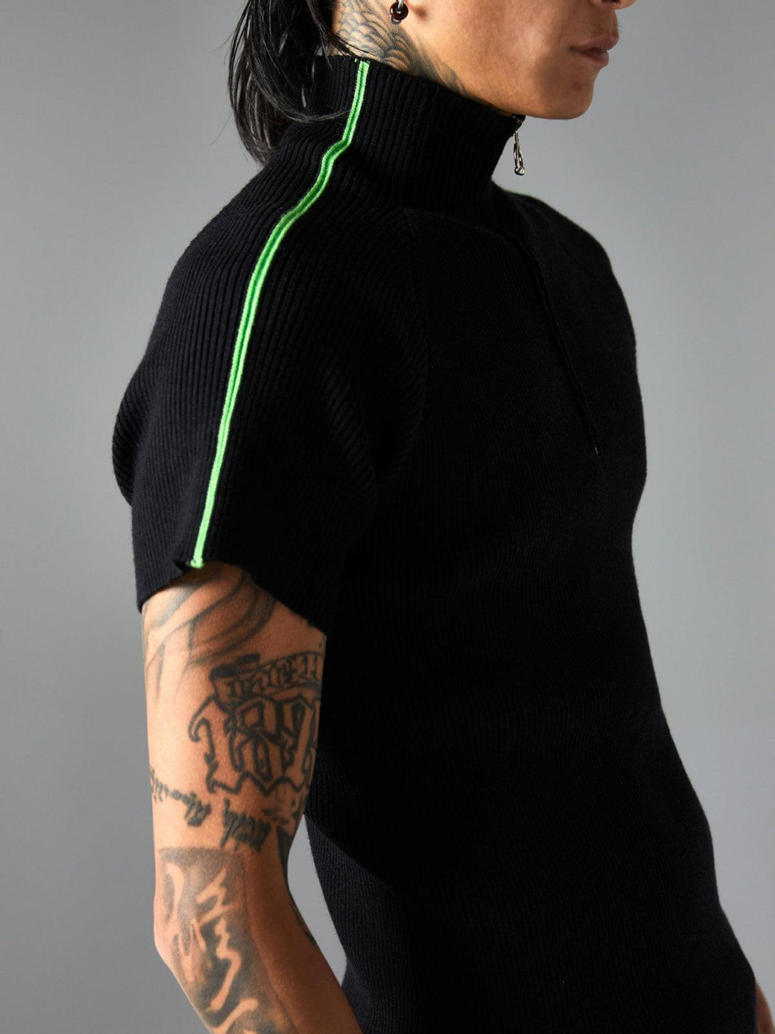 Side view of a TALISHKO retro quarter zip-up T-shirt, featuring green stripe detail.