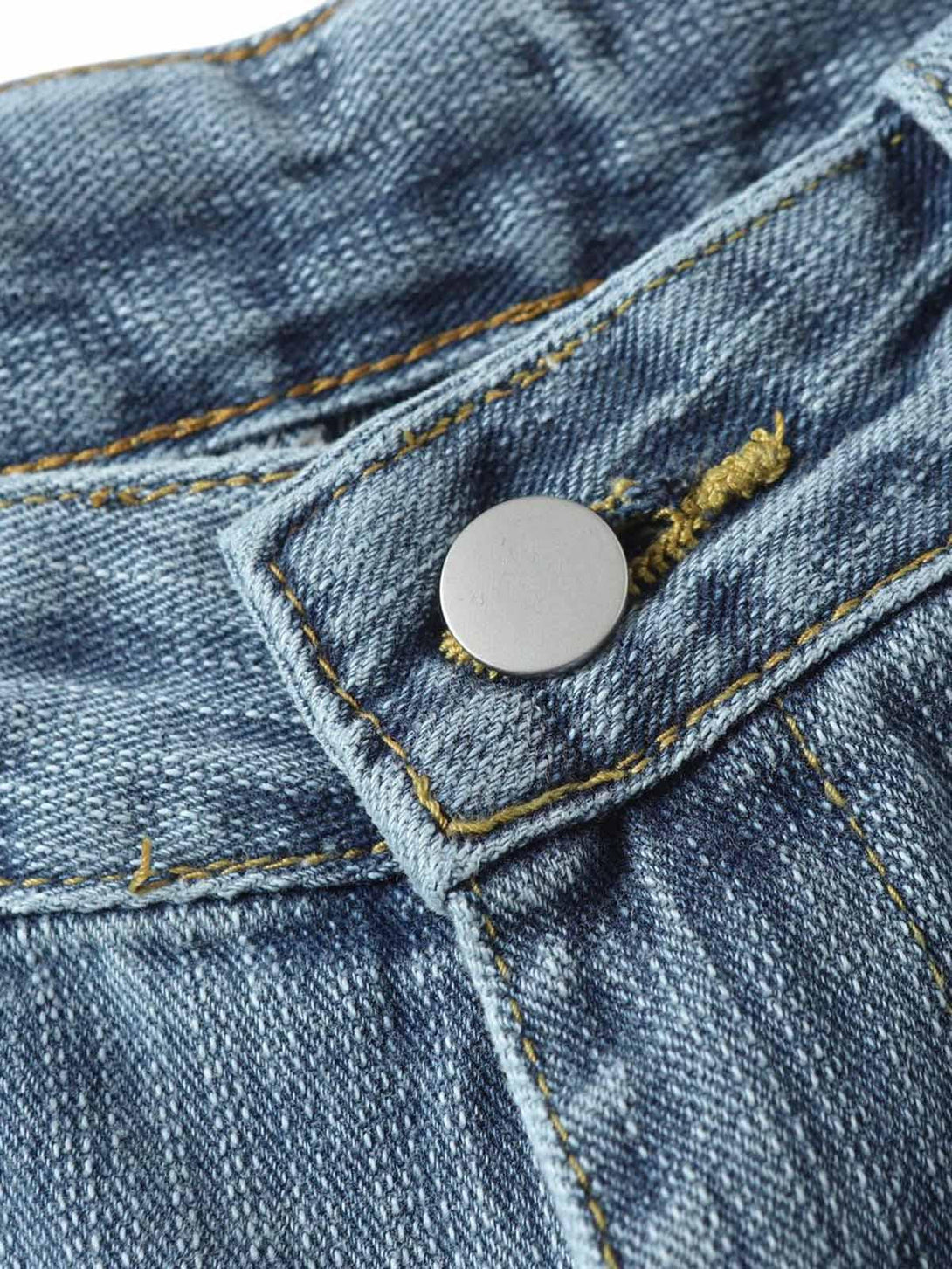 A tight crop highlighting the button detail on TALISHKO's retro cleanfit washed baggy jeans.