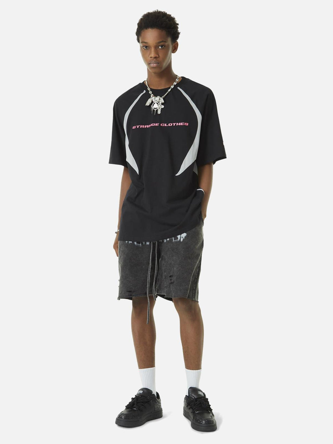 Model wearing TALISHKO's retro black racing T-shirt with bold deconstructed stitching.