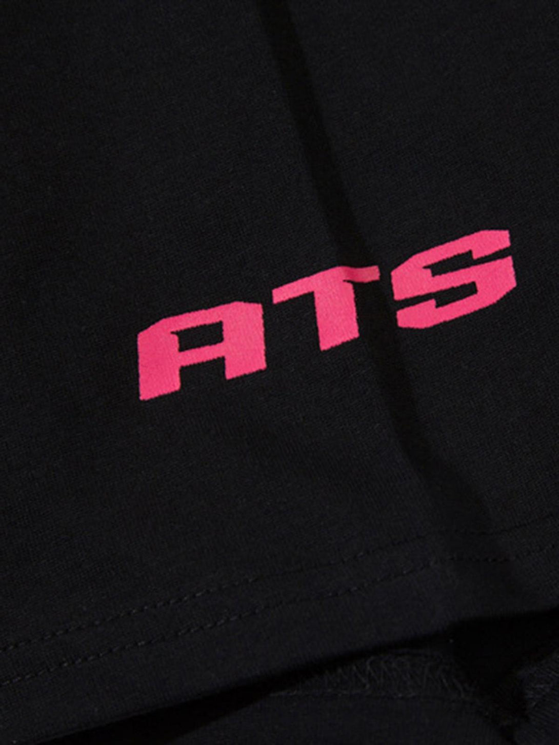 Zoomed-in texture of TALISHKO's black T-shirt showcasing bold pink "ATS" lettering.