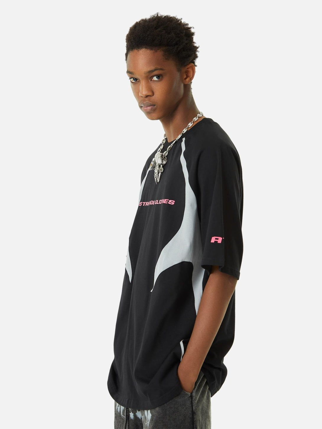 Model showcasing TALISHKO's black racing T-shirt with bold, deconstructed stitching.