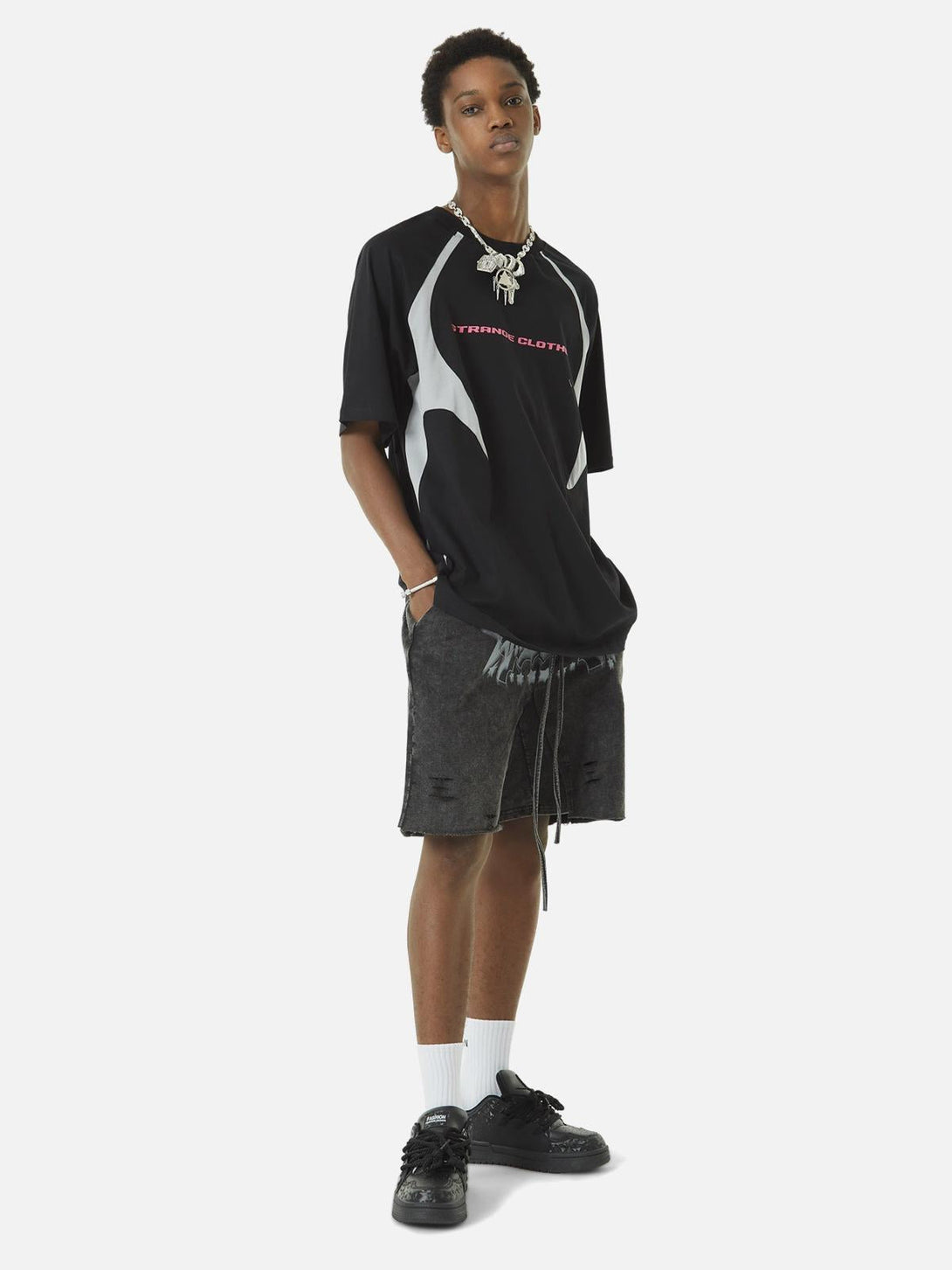 Model in TALISHKO's black racing T-shirt with retro color-blocked design and deconstructed details.