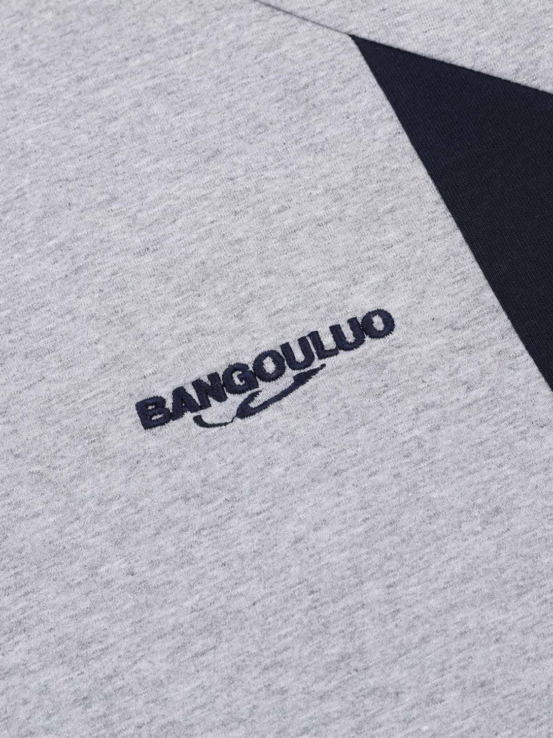 Intricate look at the embroidered lettering on a gray T-shirt by TALISHKO, featuring contrast panels.