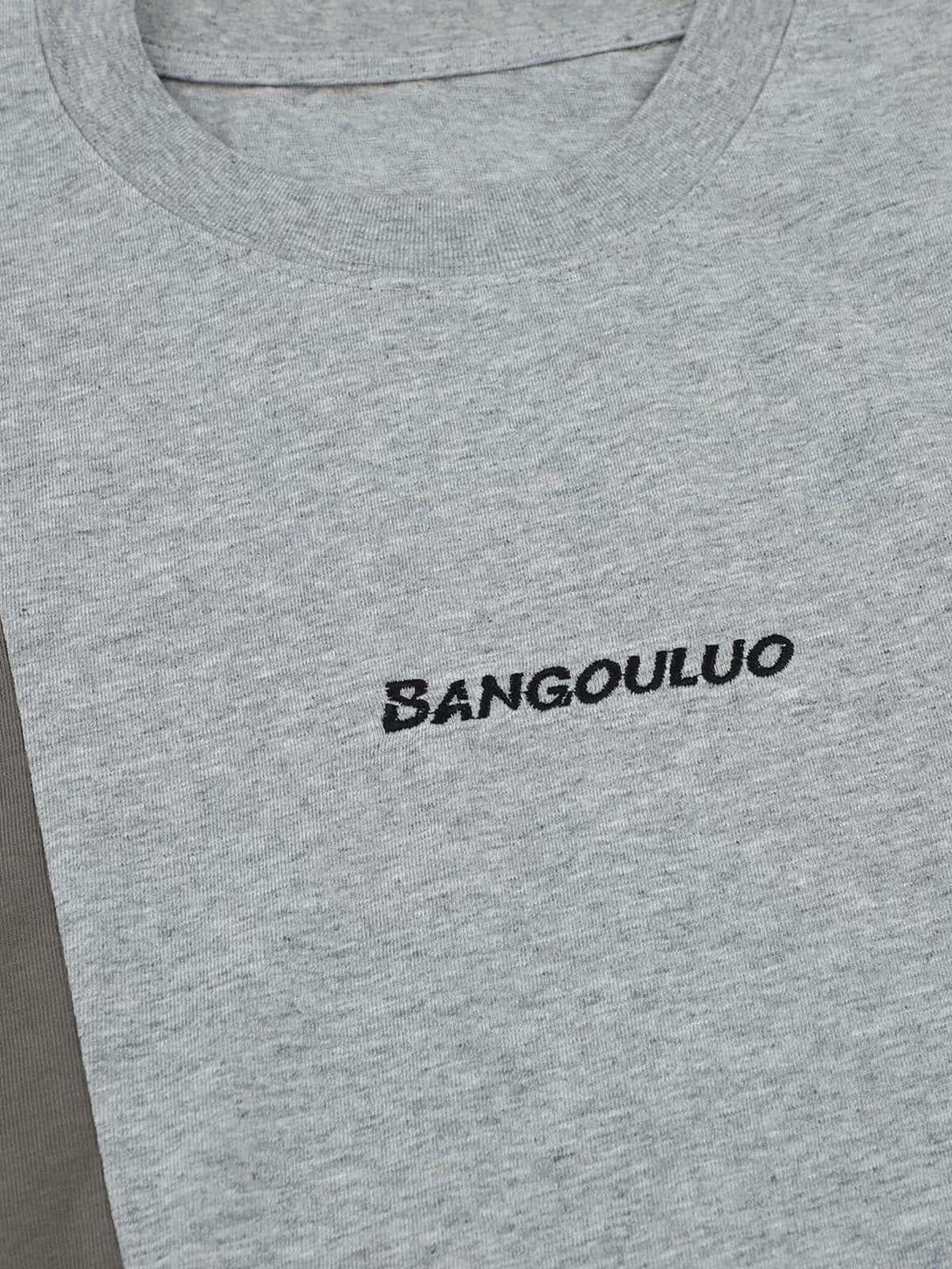 Detailed view of a gray TALISHKO T-shirt with retro stitching and embroidered lettering.