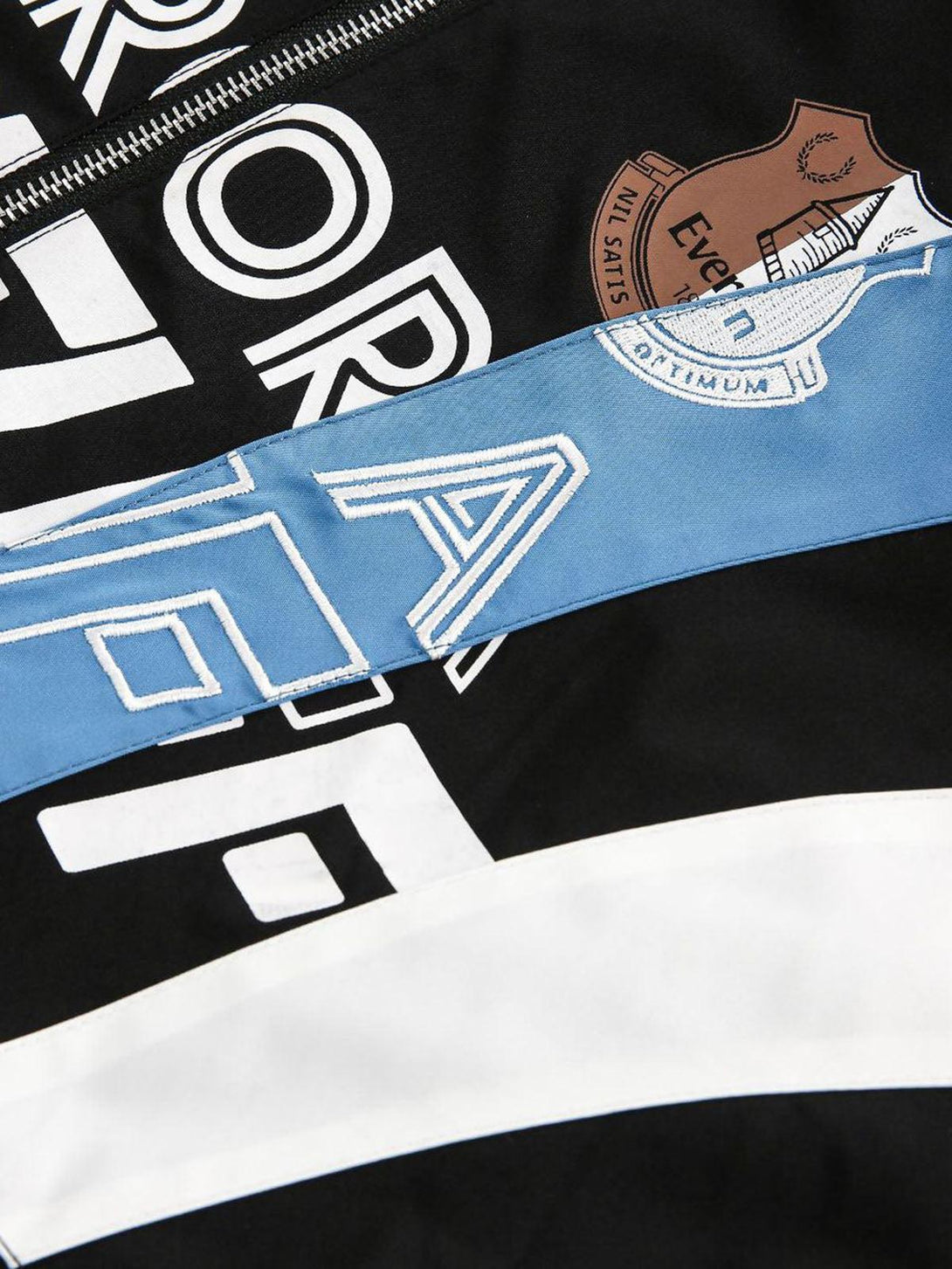 Intricate look at TALISHKO's retro jersey jacket, focusing on graphic elements and stitching.