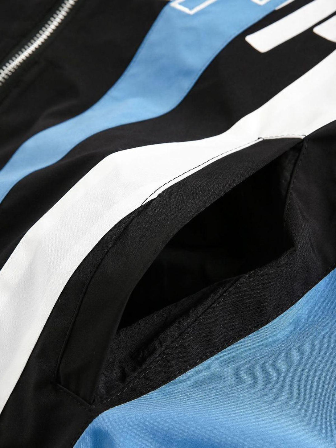 A close-up of the TALISHKO jersey jacket pocket, highlighting its retro contrast stitching.