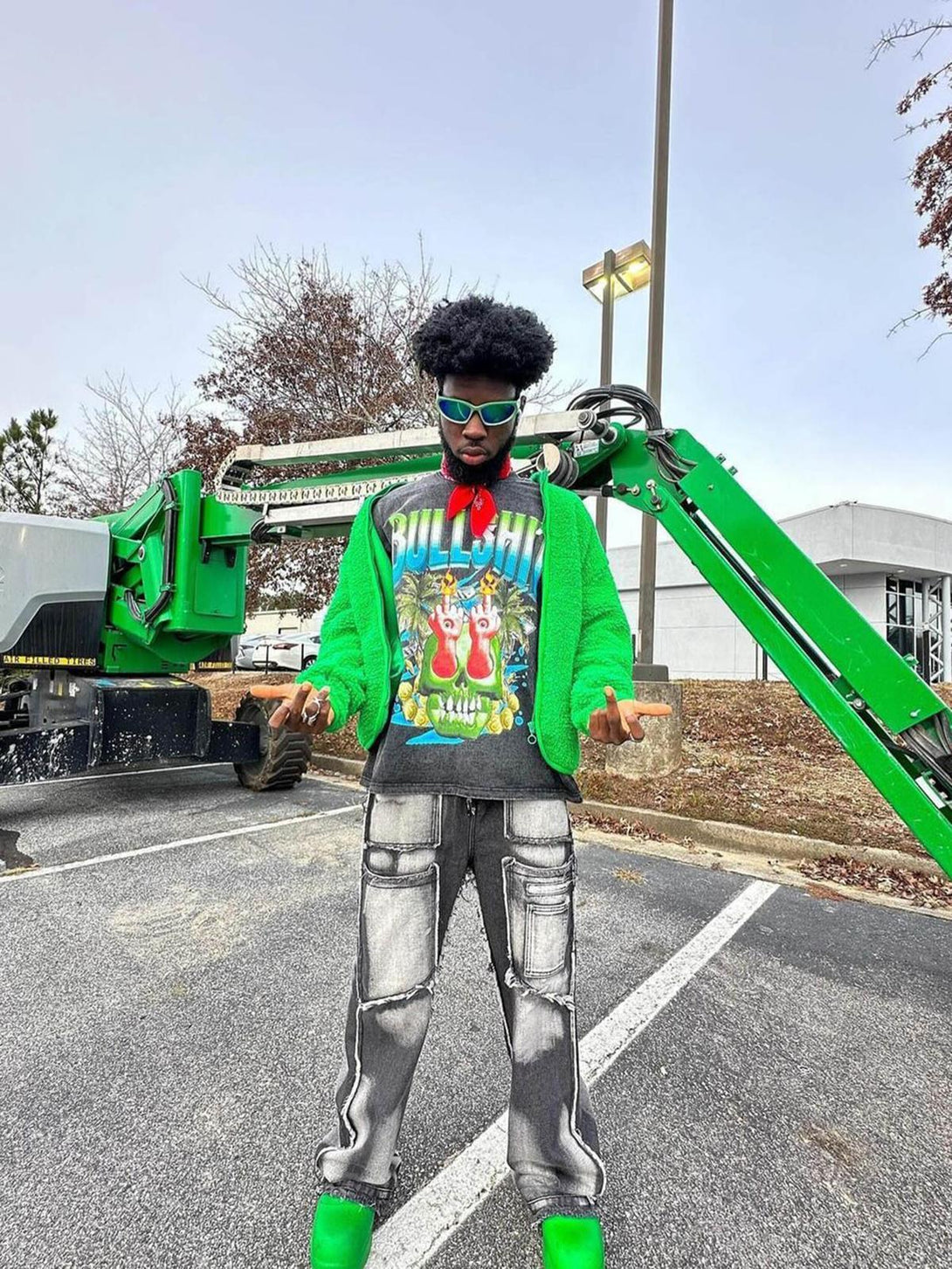 Model wearing a vibrant graphic T-shirt by TALISHKO, paired with stylish cargo pants and green shoes.