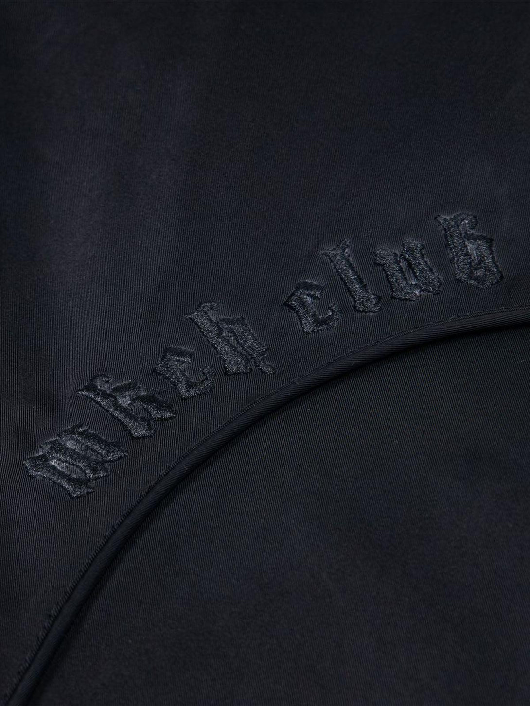 A detailed view of the embroidered design on TALISHKO's retro deconstructed bomber jacket.