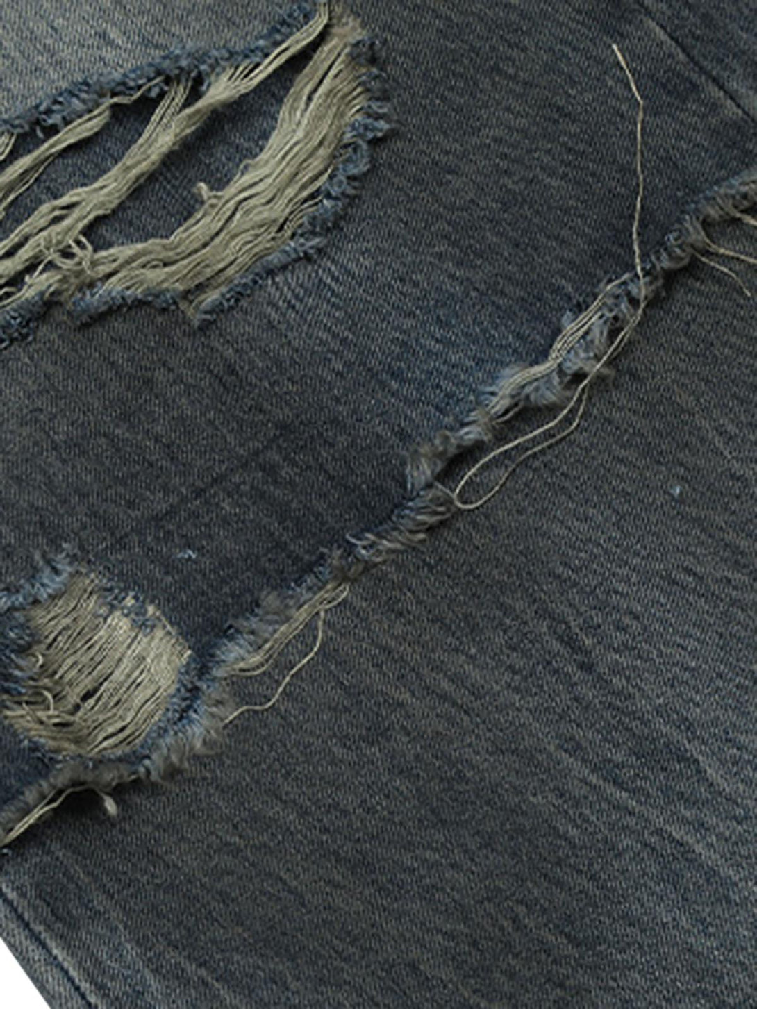 Zoomed-in detail of TALISHKO's distressed faux two-piece jeans, highlighting unique ripped texture.