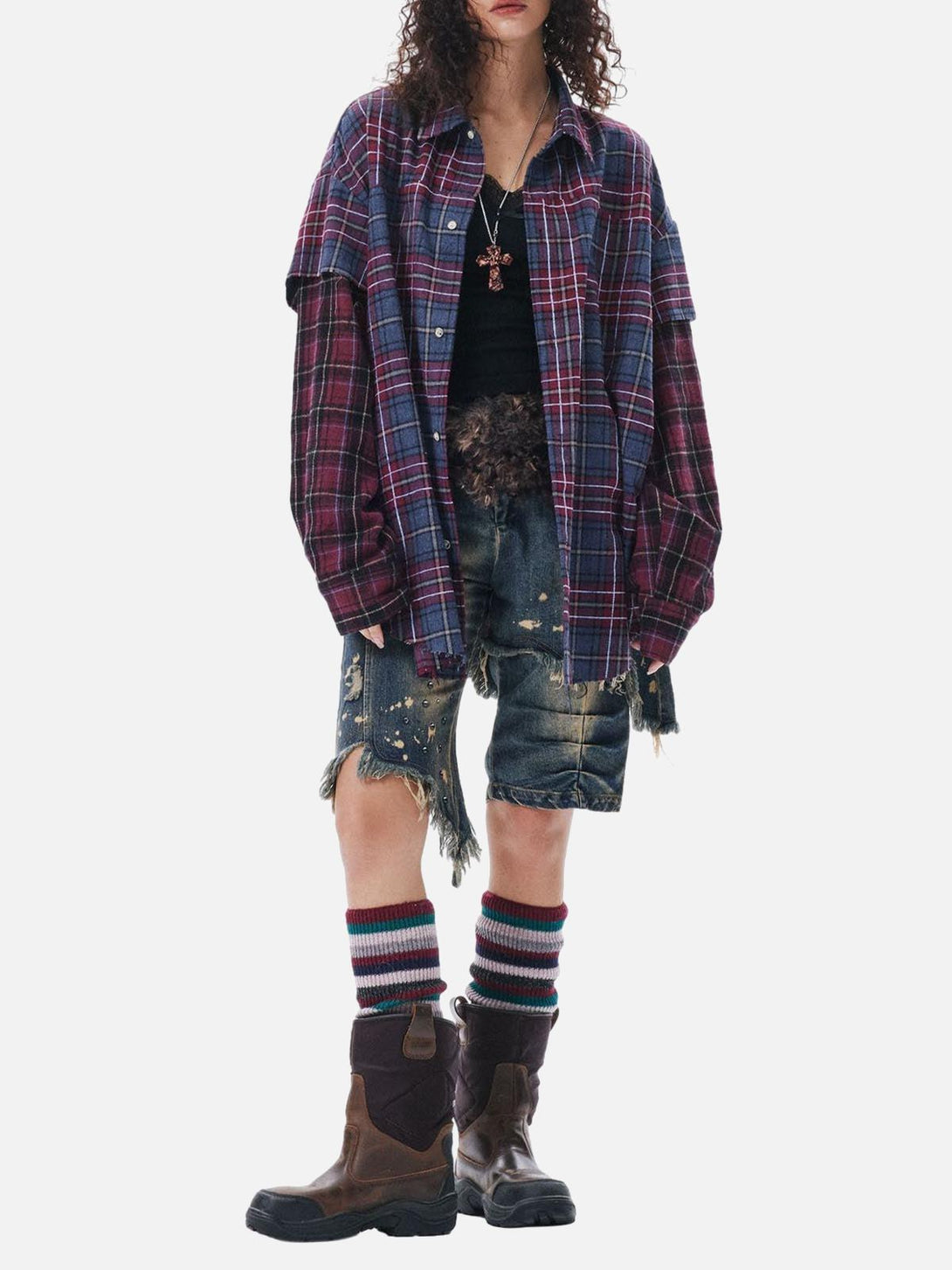 A model wears a TALISHKO plaid shirt paired with distressed shorts and boots, showcasing a retro style.