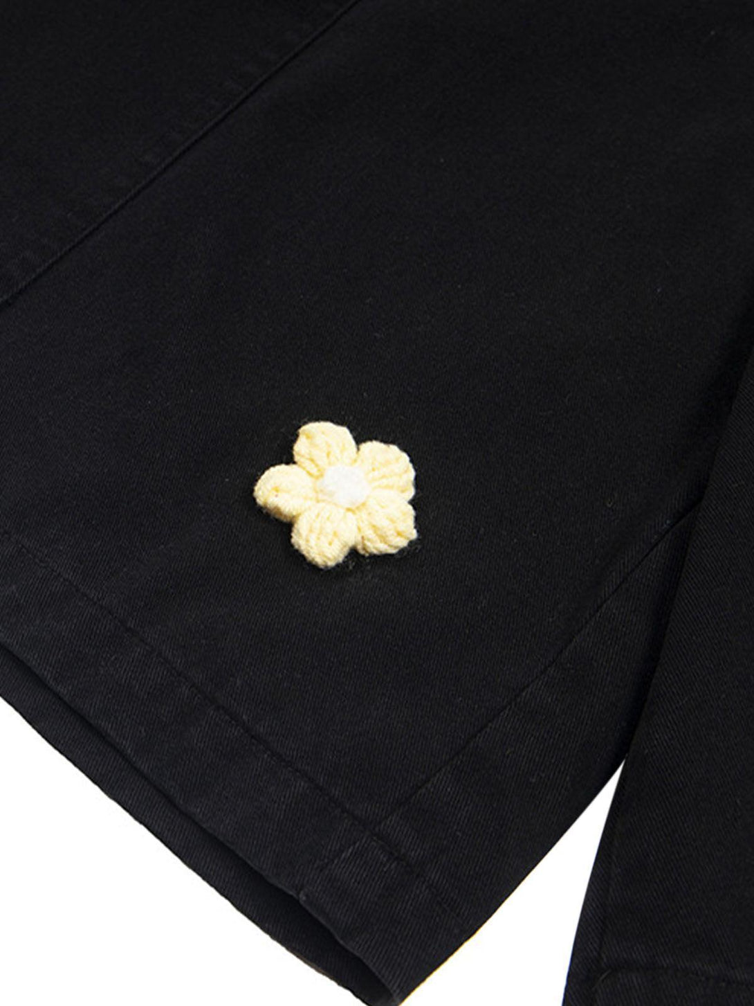 A tight crop of TALISHKO cargo jorts, highlighting the yellow floral embroidery detail.