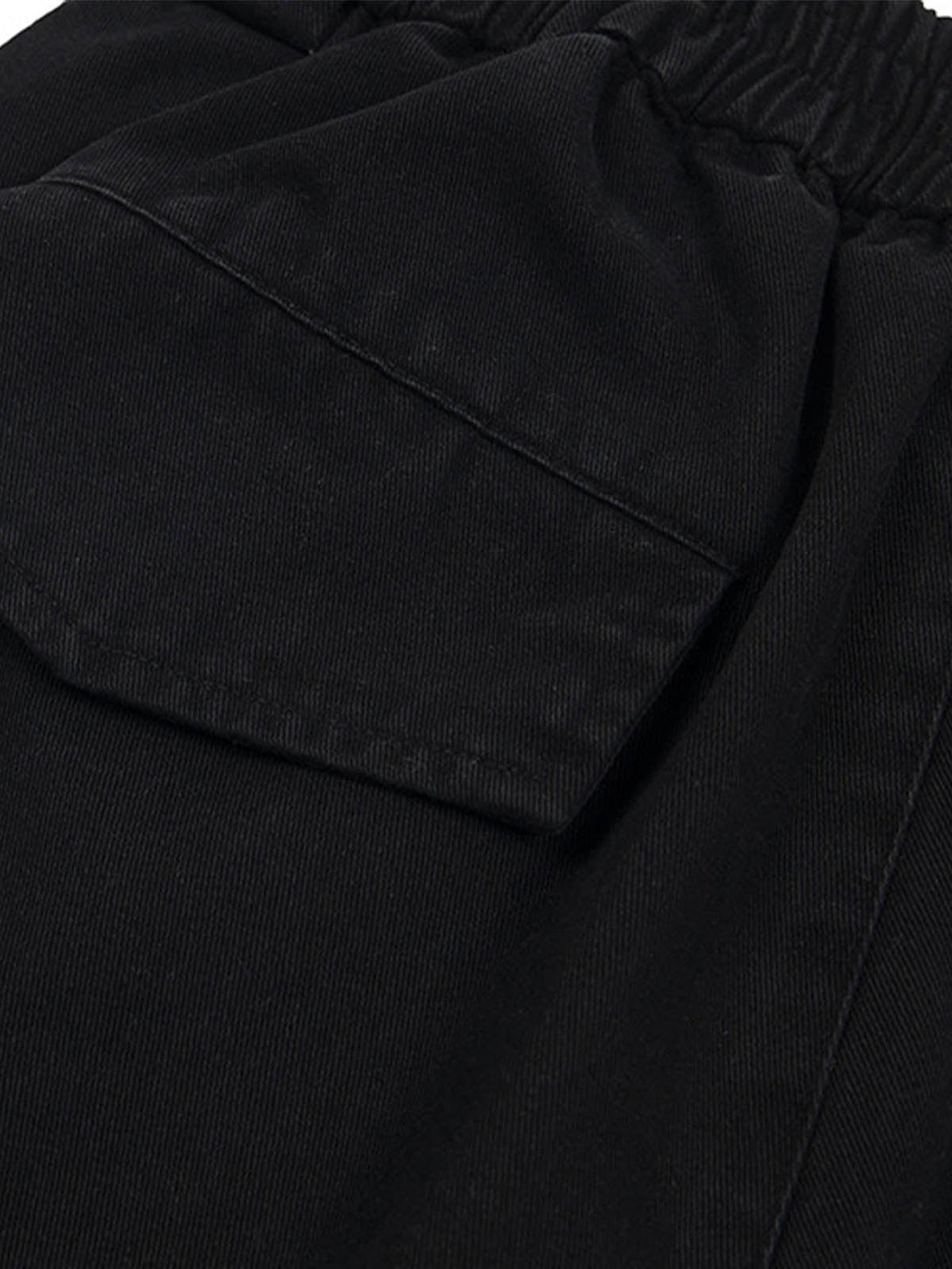 A close-up of black cargo jorts by TALISHKO, highlighting the detailed pocket stitching.