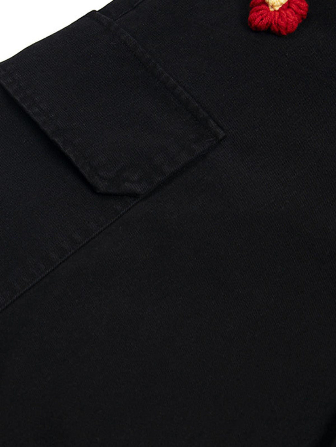 Close-up of TALISHKO black cargo jorts, featuring intricate floral embroidery detail.