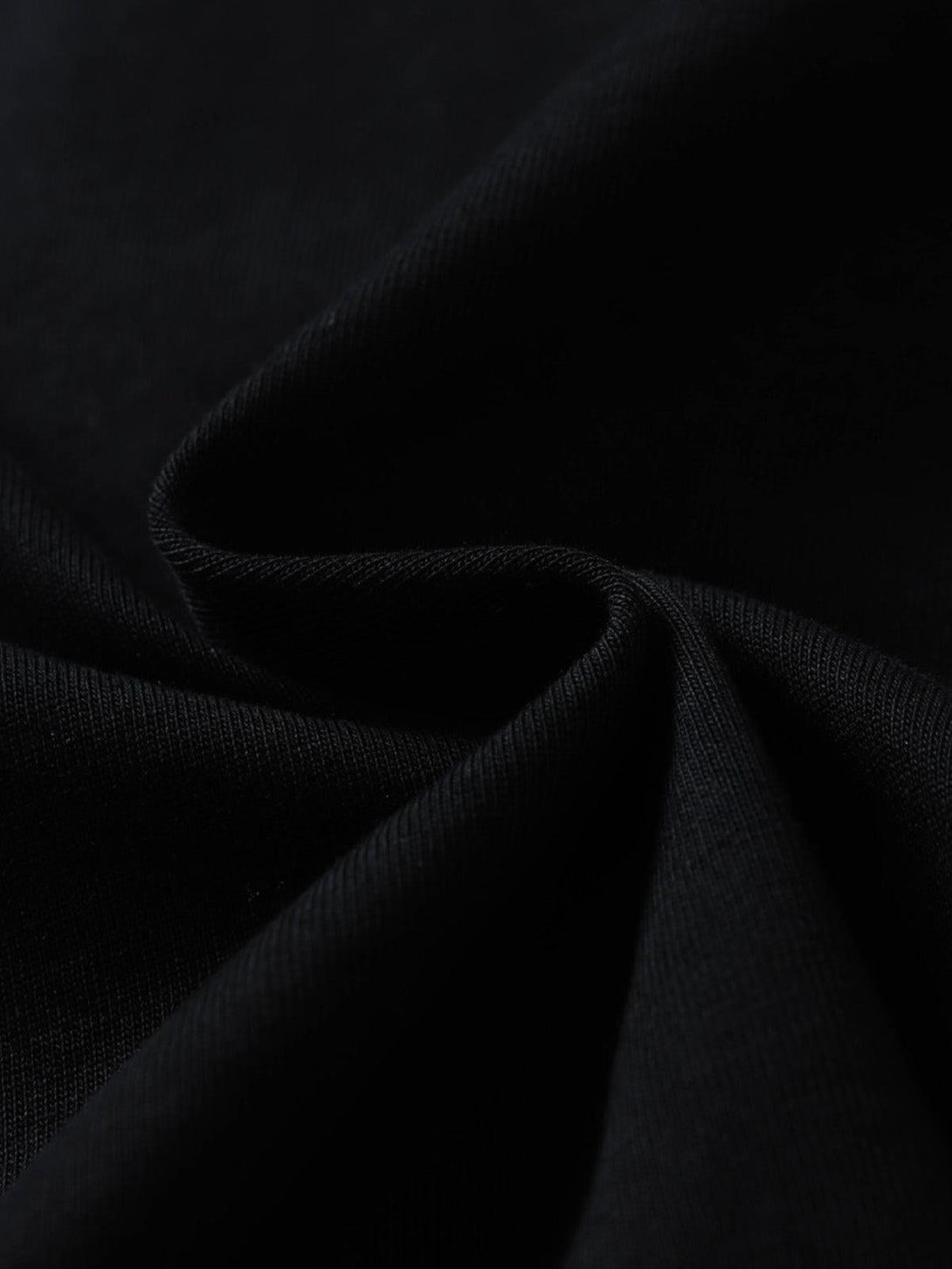 Dark fabric texture of TALISHKO's retro patchwork T-shirt, highlighting its unique craftsmanship.