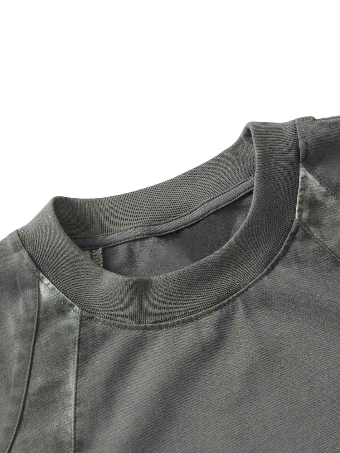 Intricate look at TALISHKO's patchwork T-shirt neckline, showcasing its unique texture.