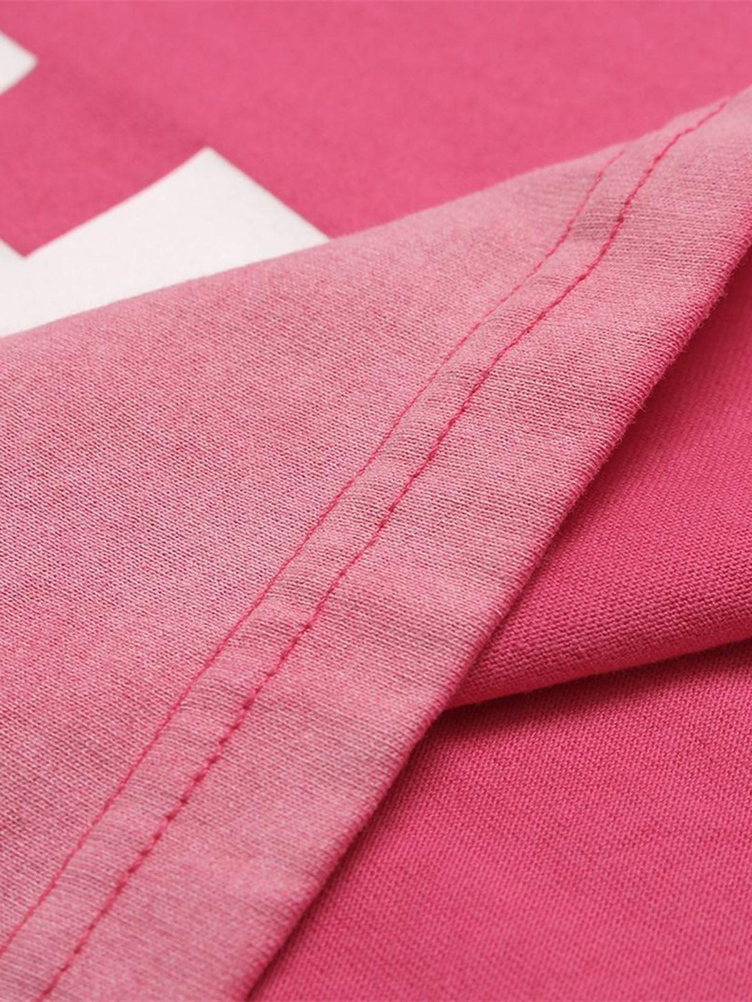 Detailed fabric and stitching of TALISHKO retro gradient T-shirt, showcasing vibrant pink hue.