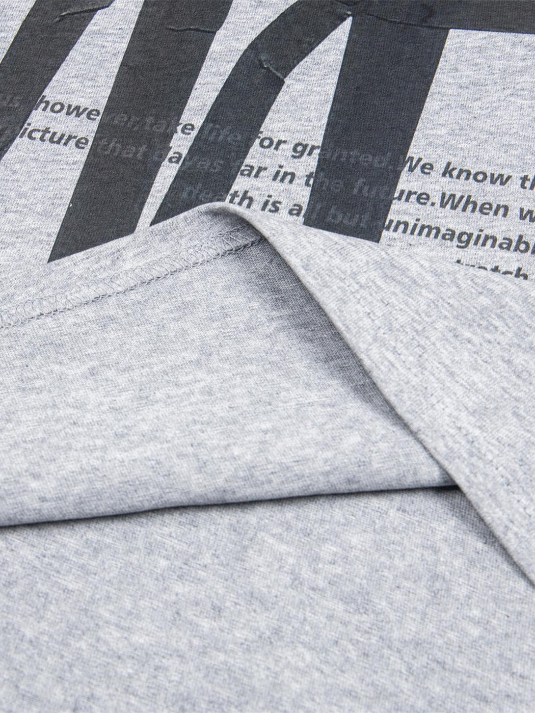 Detailed fabric and stitching of TALISHKO T-shirt, highlighting retro lettering design.