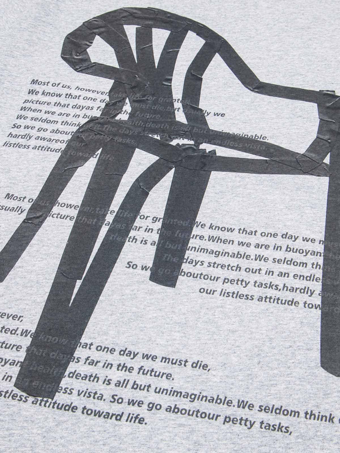 TALISHKO T-shirt detail showcasing retro chair graphic and artistic lettering on gray fabric.